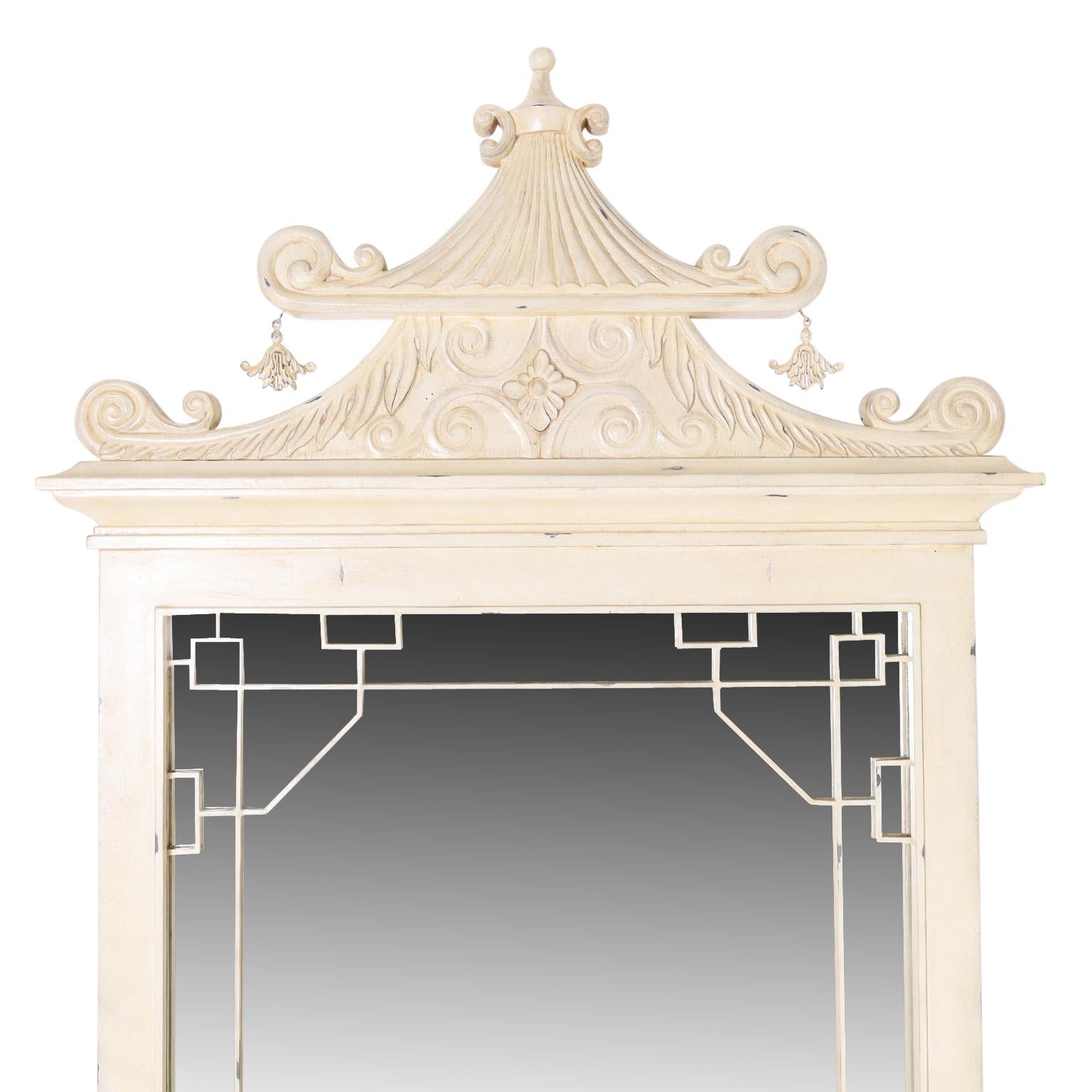 Giant pagoda form floor or wall mirror crafted in metal having a cream lacquer finish with contrived aging.