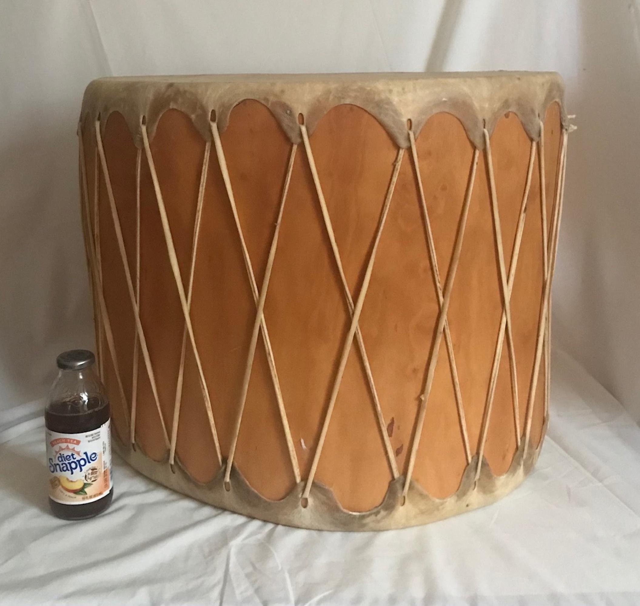 Huge vintage pueblo Native American double sided drum

This extra large drum is handmade by the Cochiti Pueblo people, a native tribe of New Mexico. It is exquisitely crafted from a hollowed single log of the cottonwood tree. The rawhide is