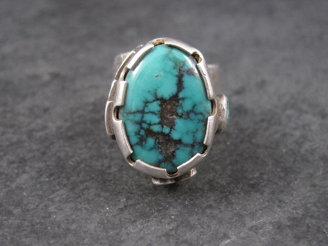 This stunning turquoise Kewa ring is an amazing combination of techniques.
It bears a modernist design with its high setting and overlaid symbology.
The band is sand cast and is done with a step design.

Despite its unusual design, its actually a