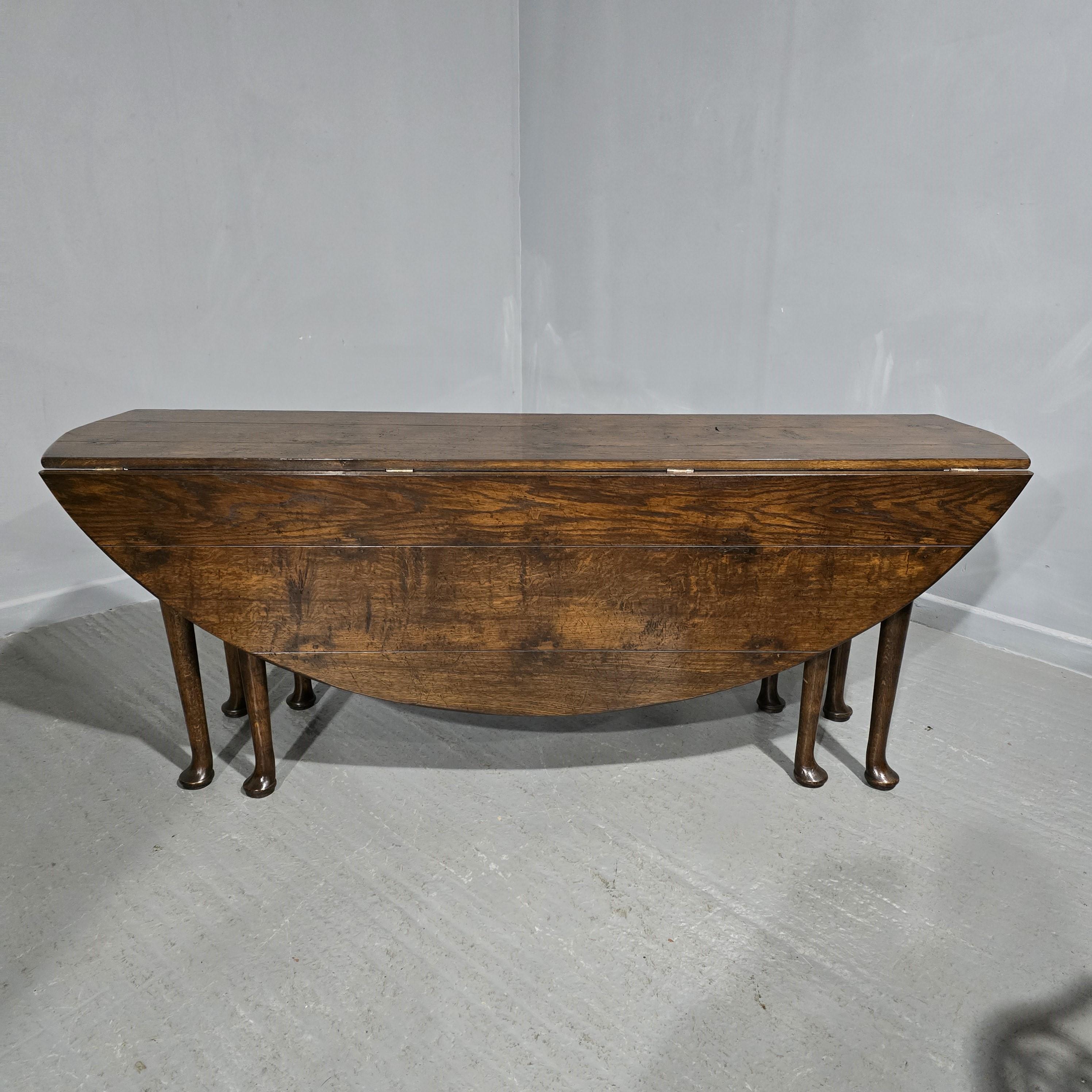 Une immense table de ferme, de cuisine, de veillée, à feuilles tombantes avec un double pied de porte, en chêne planchéié et joint par chevilles partout, en excellent état général avec un pied de pad, pouvant facilement accueillir 10 personnes.

30