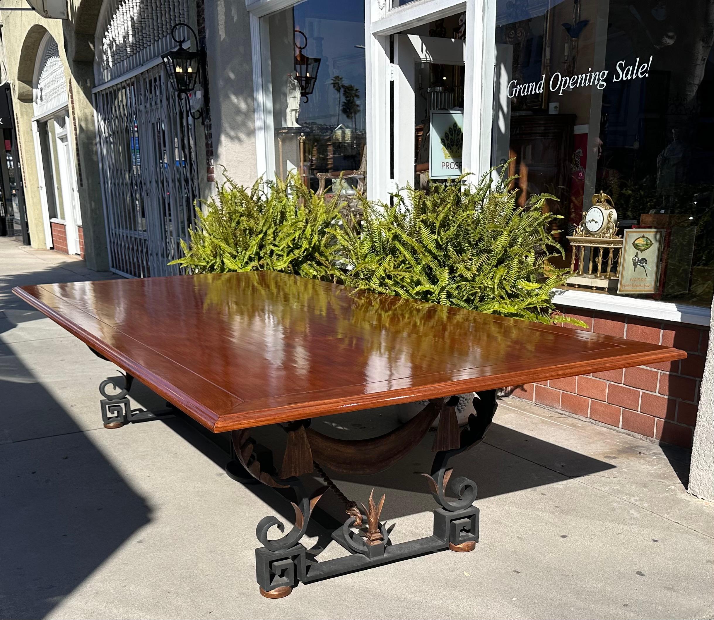 Huge Formations Furniture Wrought Iron & Gilt Metal 10’ Mahogany Dining Table. It features a Greek key and swag heavy metal base with a rustic European top.