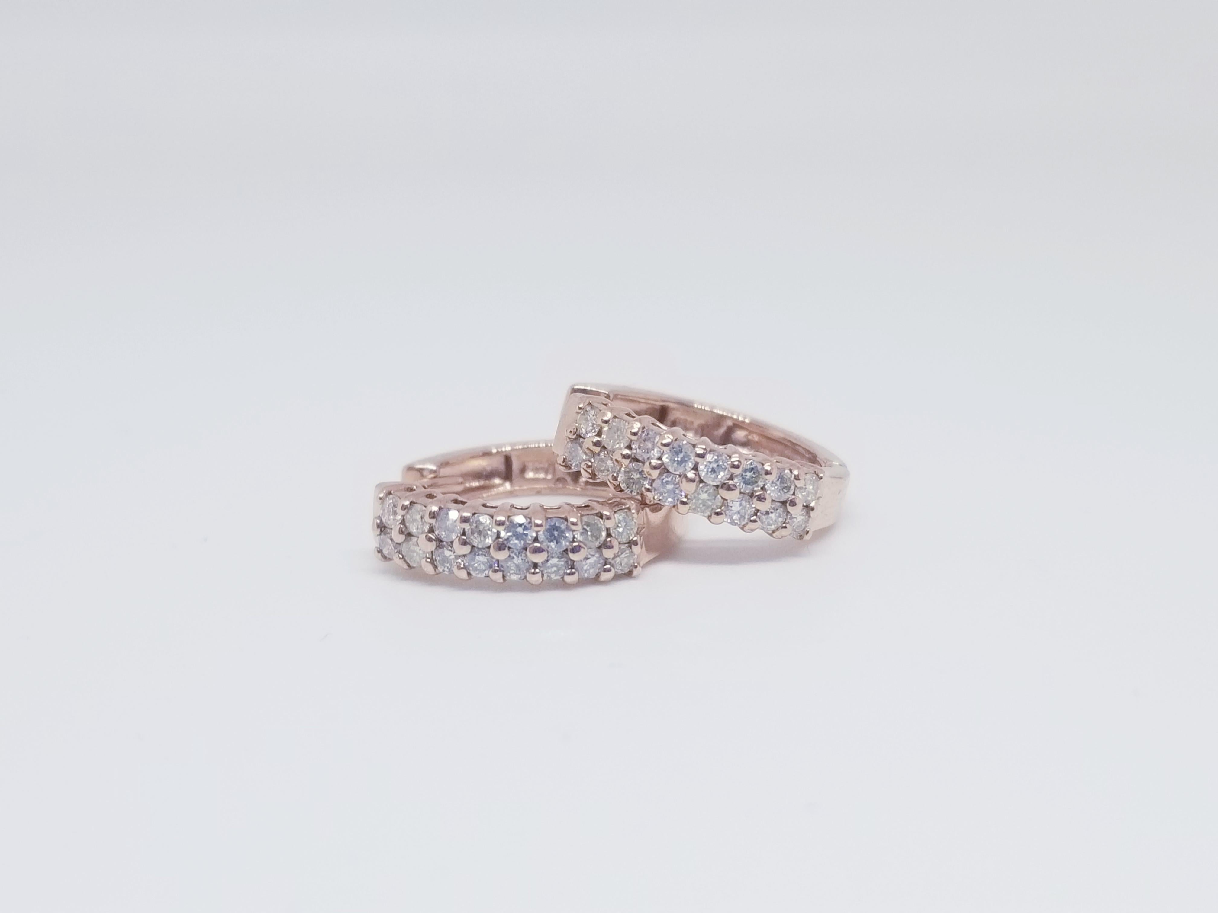 Beautiful shiny pair of huggie diamond hoop earrings in 14k rose gold. Double row design features 32 round diamonds that weight approximately 0.89cttw. Secure with snap closure. Measures 1.5 mm in diameter and weighs 3.24 grams.