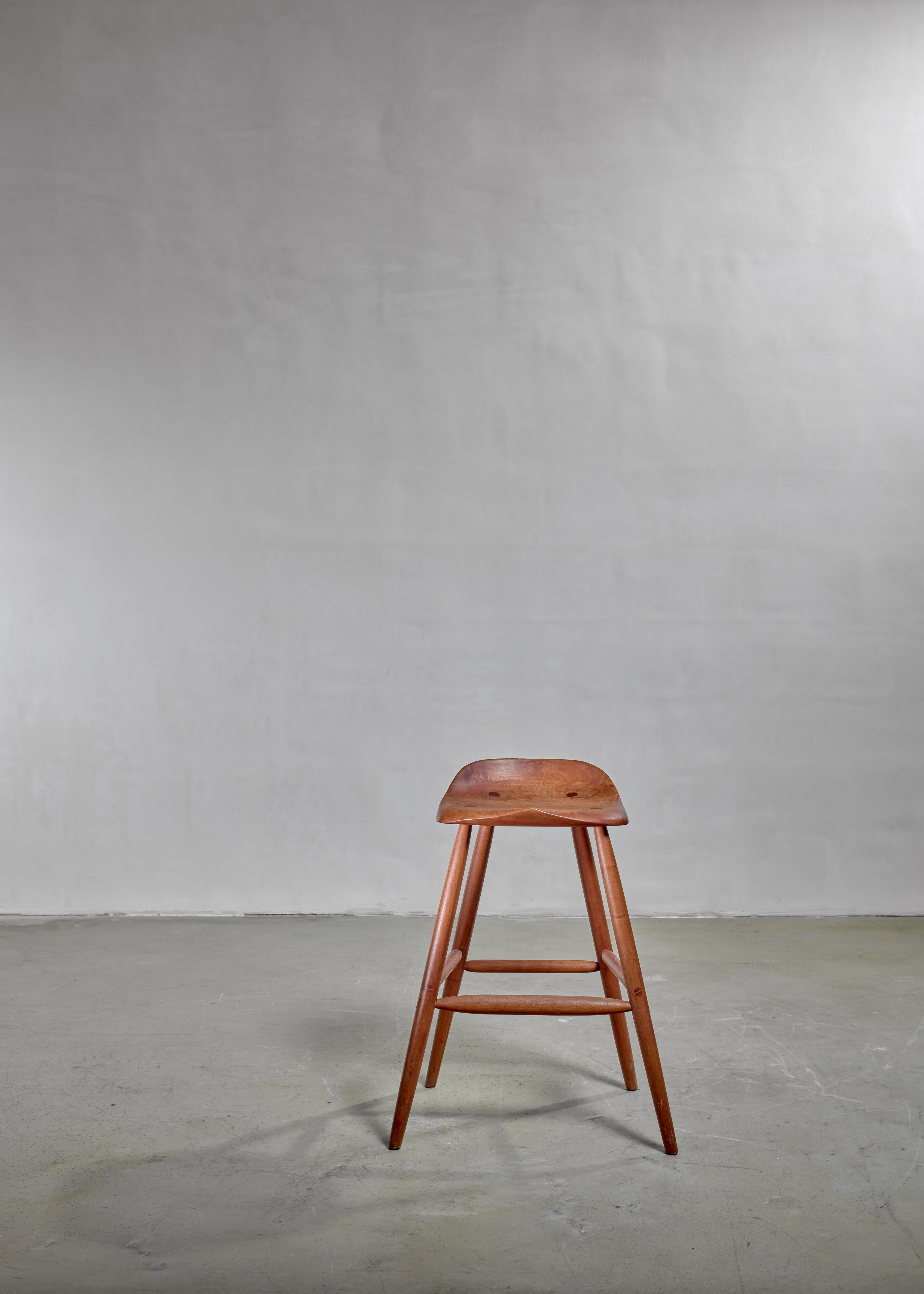 A wonderful bar or studio stool in walnut by Hugh Davies. The stool has a wonderfully sculpted and curved seating, for more comfort. The visible connections in the seating are a beautiful detail.
In a perfect condition and branded by Davies