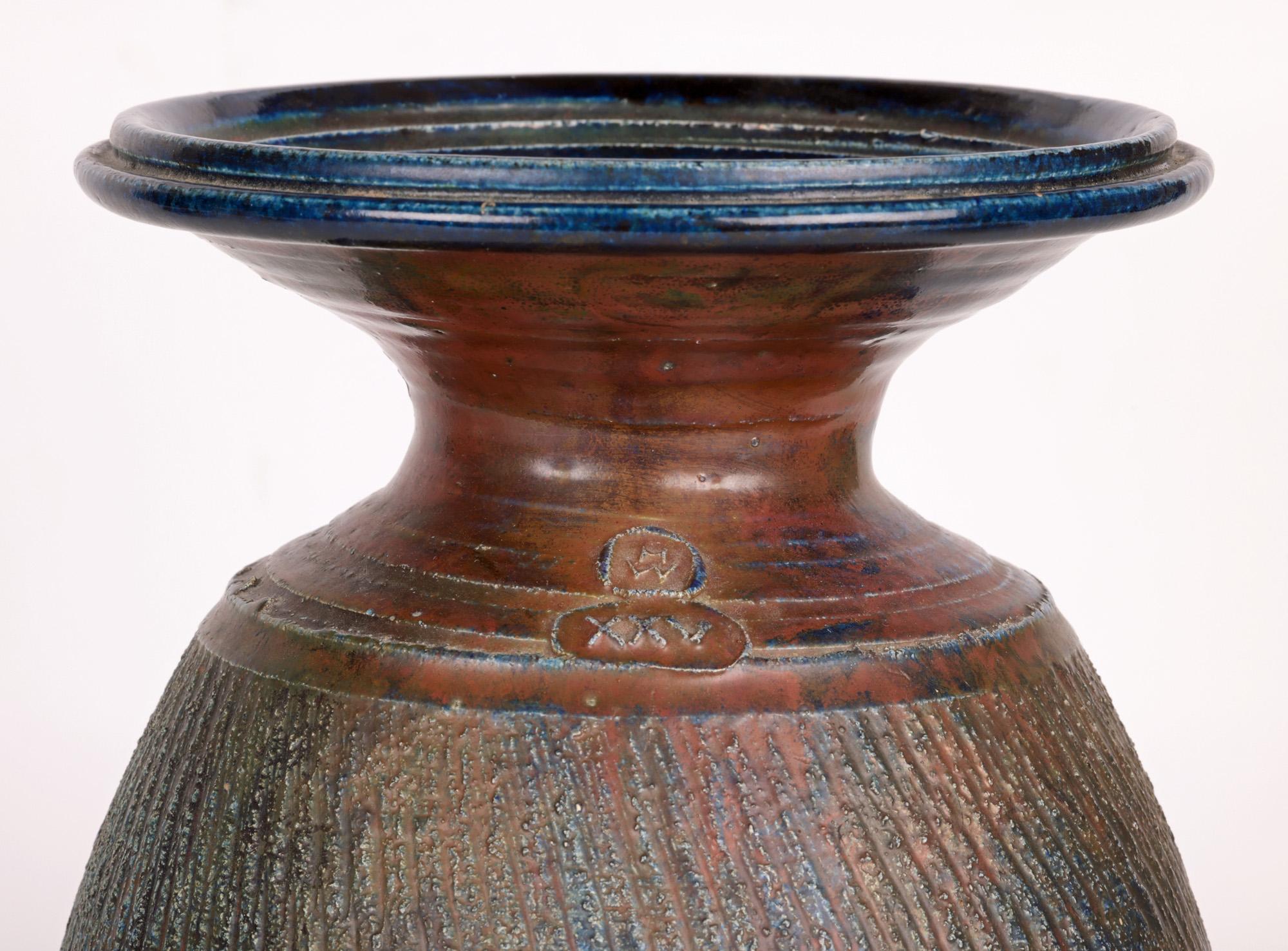 Exceptionnel, grand et impressionnant vase en émail raku de Carnon Downs Pottery avec des motifs nervurés, réalisé lors du 25e anniversaire par le célèbre potier Hughes West (britannique, né en 1950) et datant de 1996. Le grand vase de forme