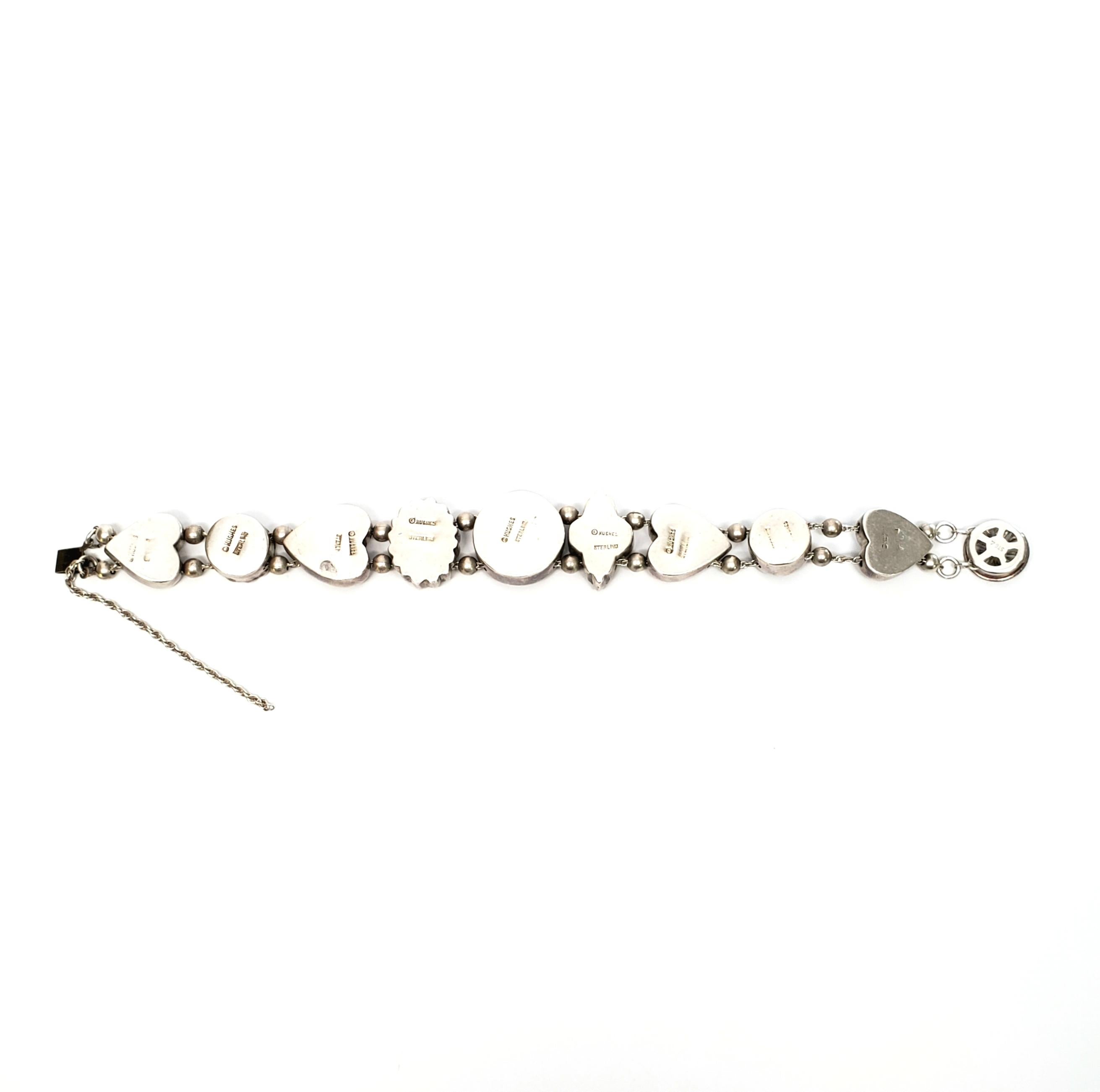 Vintage sterling silver slide charm bracelet by designer Hughes.

The 