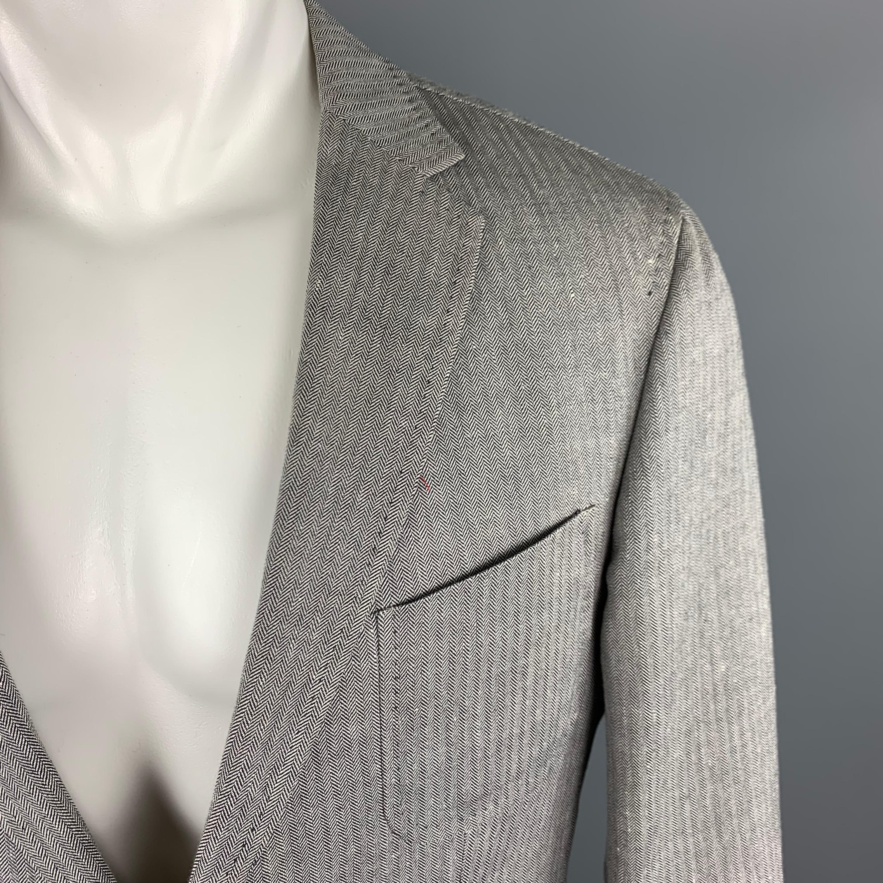 HUGO BOSS Sport Coat comes in a grey tone in a herringbone wool / linen material, with a notch lapel, patch pockets, two buttons at closure, single breasted, double vent at back and buttoned cuffs, unlined.
 
Excellent Pre-Owned Condition.
Marked: