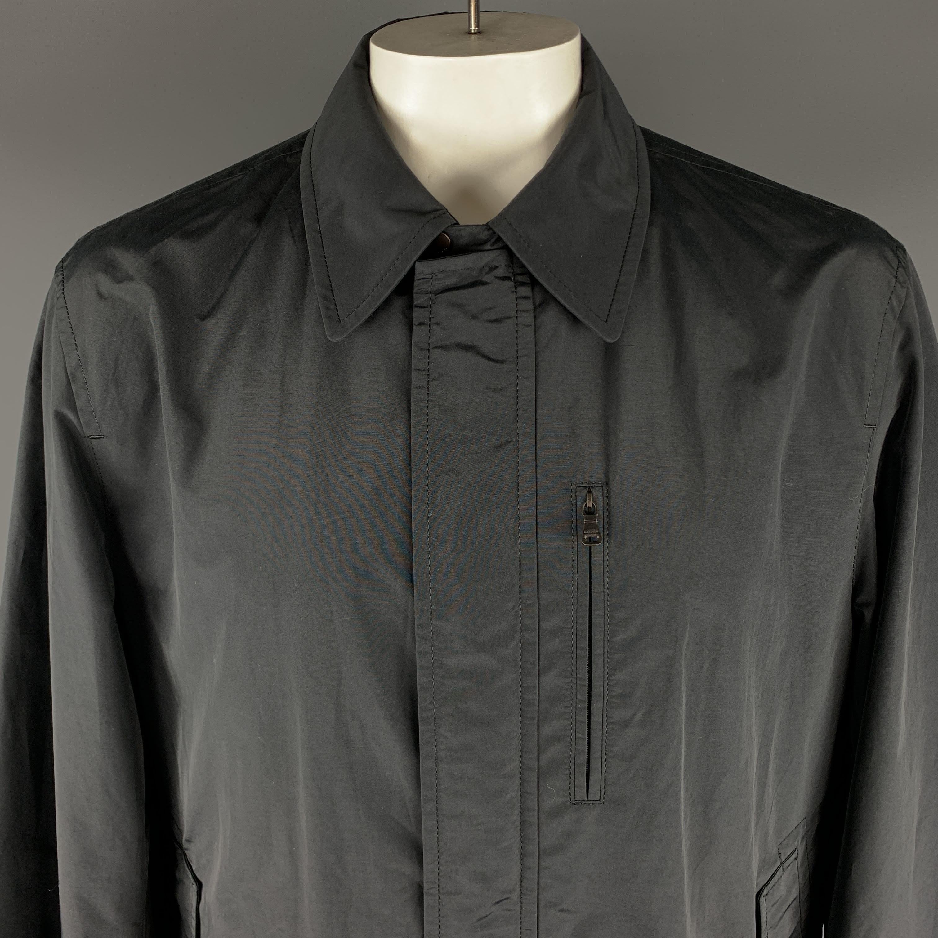 HUGO BOSS Langer Mantel in Schwarz aus festem Baumwoll-/Nylonmaterial, mit spitzem Kragen, Reißverschluss und Druckknöpfen am Verschluss sowie Reißverschluss- und Einschubtaschen. Ausgezeichneter Pre-Owned Zustand. 

Markiert:   IT 56
