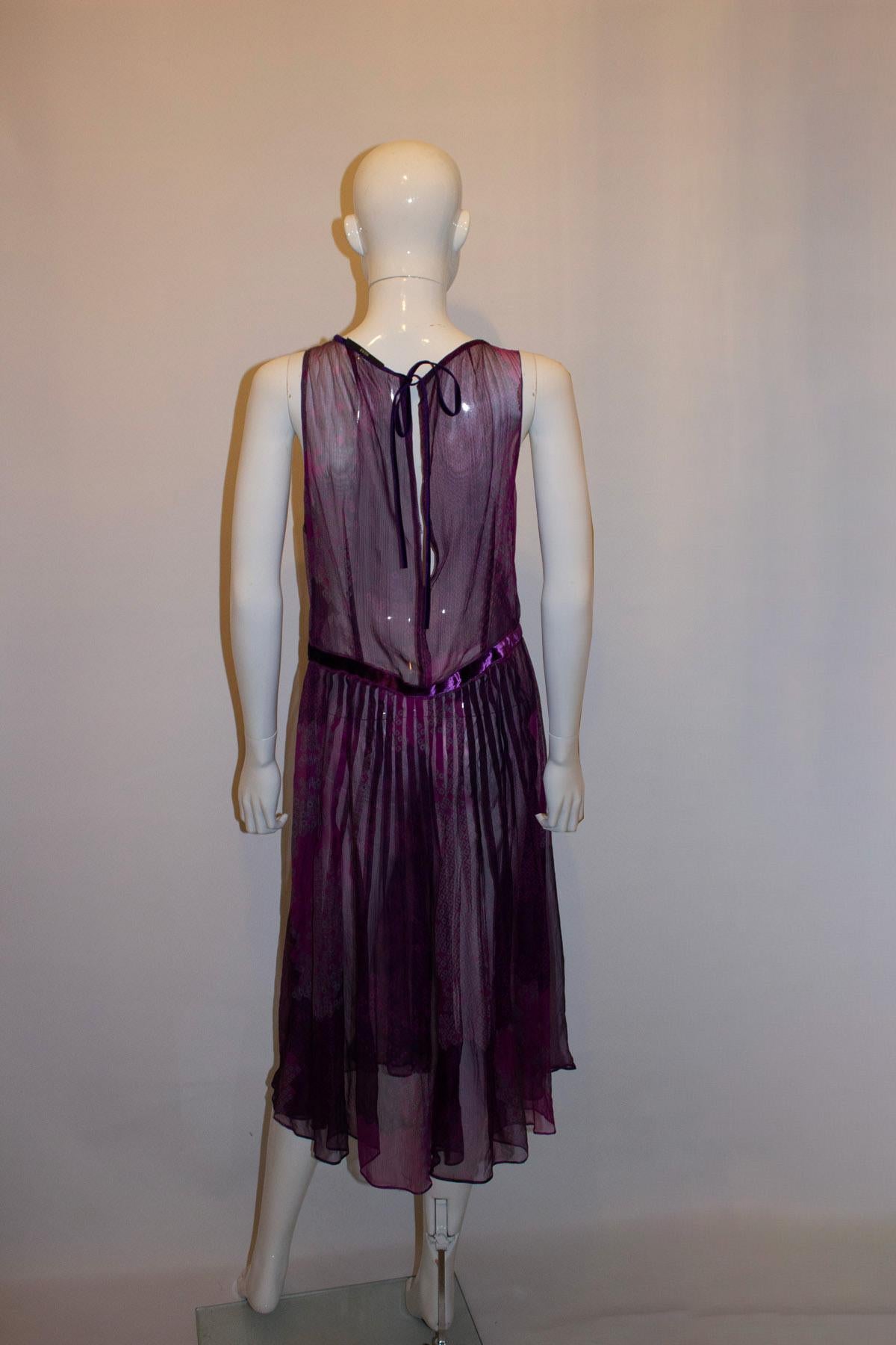 Un vestido estupendo para una fiesta de otoño de Hugo Boss. El vestido tiene un estampado maravilloso y una combinación de colores rosa y morado. Necesita un deslizamiento y eso podría integrarse en la combinación de colores. En  tiene una