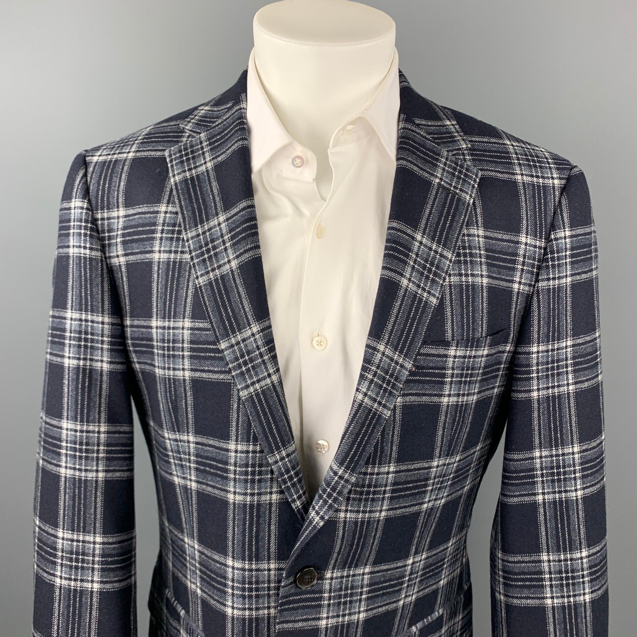 HUGO BOSS sport coat comes in a navy & grey plaid cashmere made from Loro Piana featuring a notch lapel, flap pockets, and a two button closure.

Very Good Pre-Owned Condition.
Marked: US 38 R 

Measurements:

Shoulder: 18.5 in. 
Chest: 40 in.