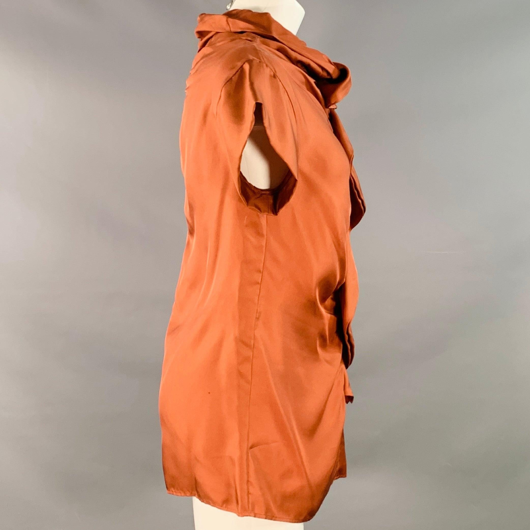 Blusa BOSS by HUGO BOSS
en sarga de seda marrón cobrizo con volantes en la parte delantera, cuello alto, mangas cortas y cierre de cremallera en la espalda.Muy buen estado de segunda mano. Varias marcas menores. 

Marcado:   IT 40 

Medidas: 
