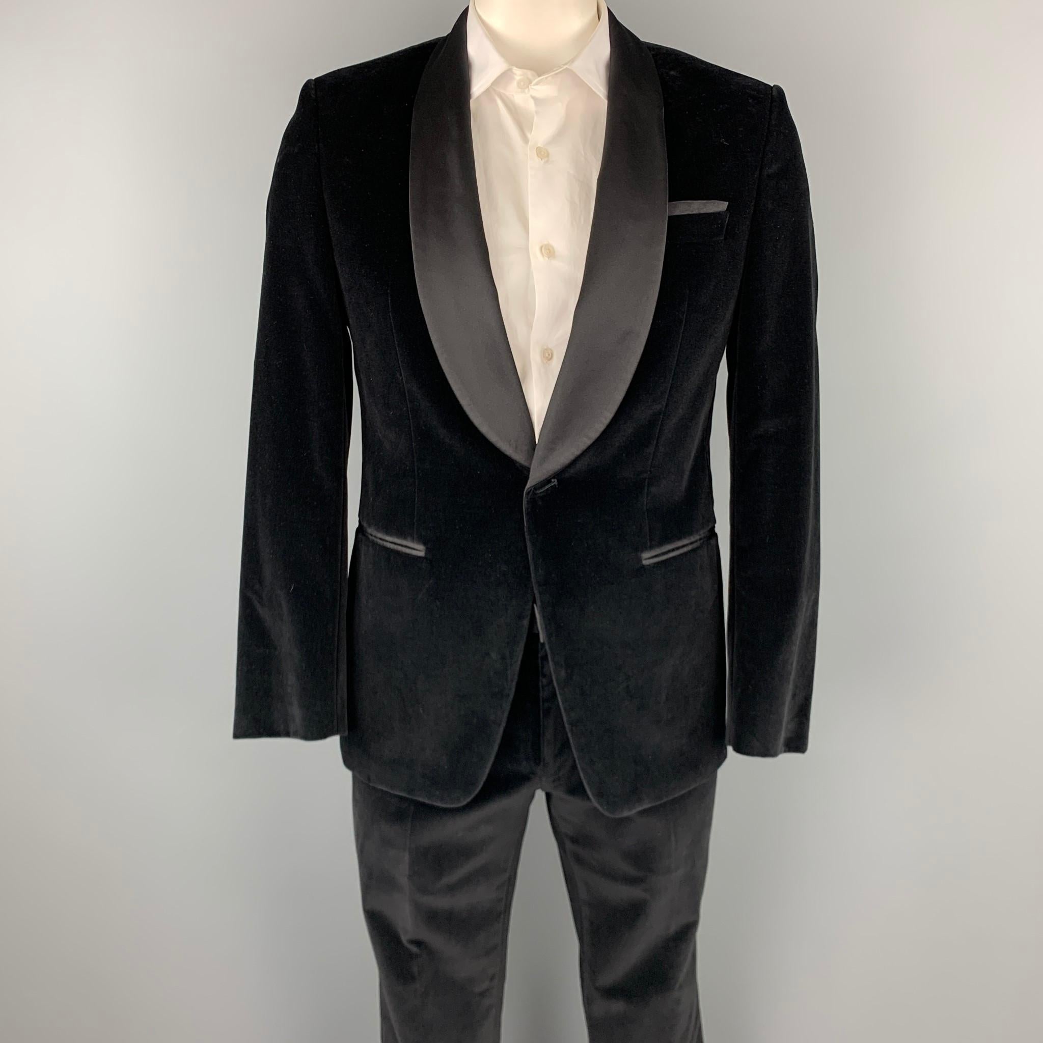 HUGO BOSS suit comes in a black cotton velvet with a full liner and includes a single breasted, single button sport coat with a shawl collar and matching flat front trousers. 

New With Tags.
Marked:

Measurements:

-Jacket
Shoulder: 18.5 in.
Chest: