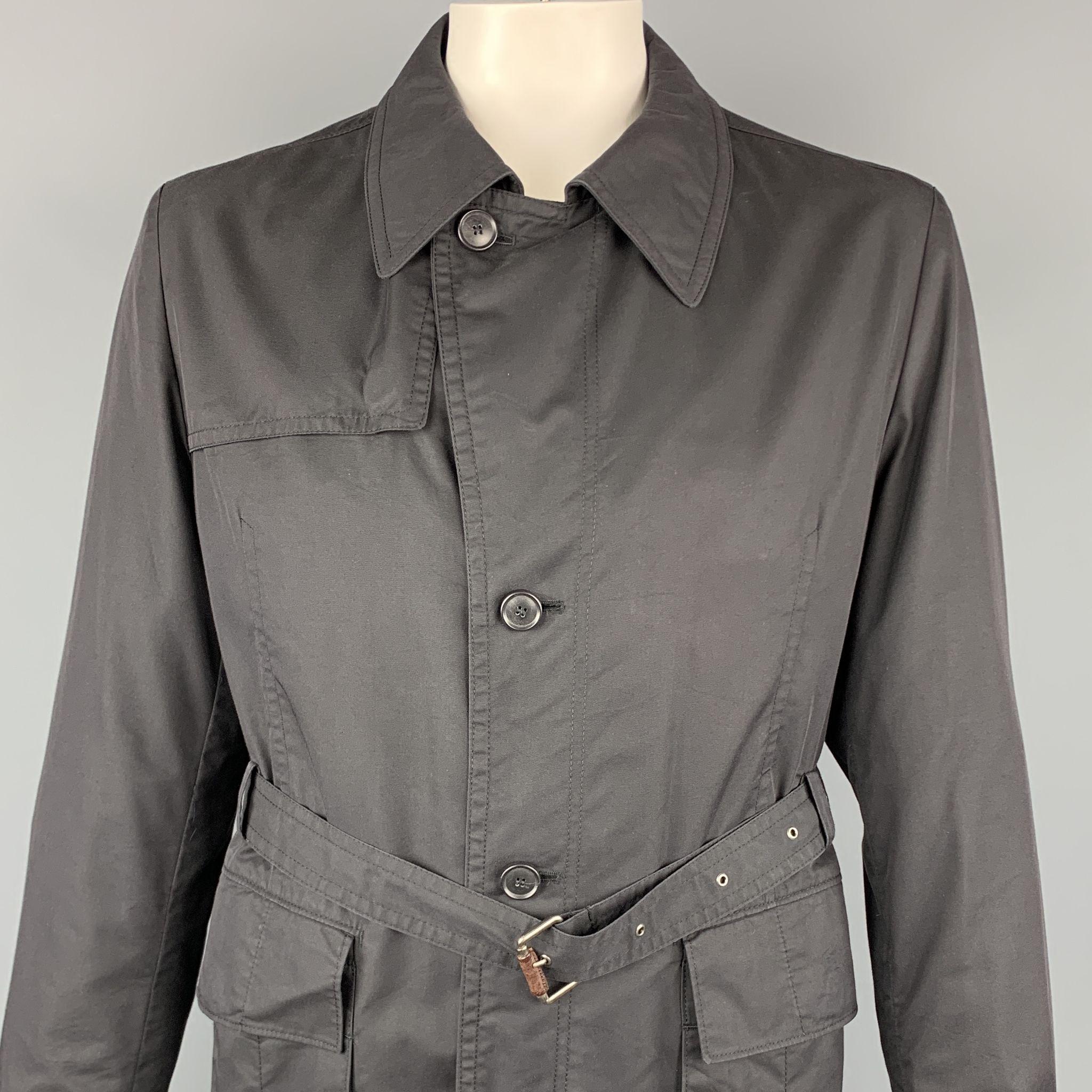 HUGO BOSS jacket comes in a black cotton blend featuring a belted style, patch pockets, and button details.

Very Good Pre-Owned Condition.
Marked: 44

Measurements:

Shoulder: 17.5 in.
Chest: 44 in.
Sleeve: 27 in.
Length: 28.5 in.