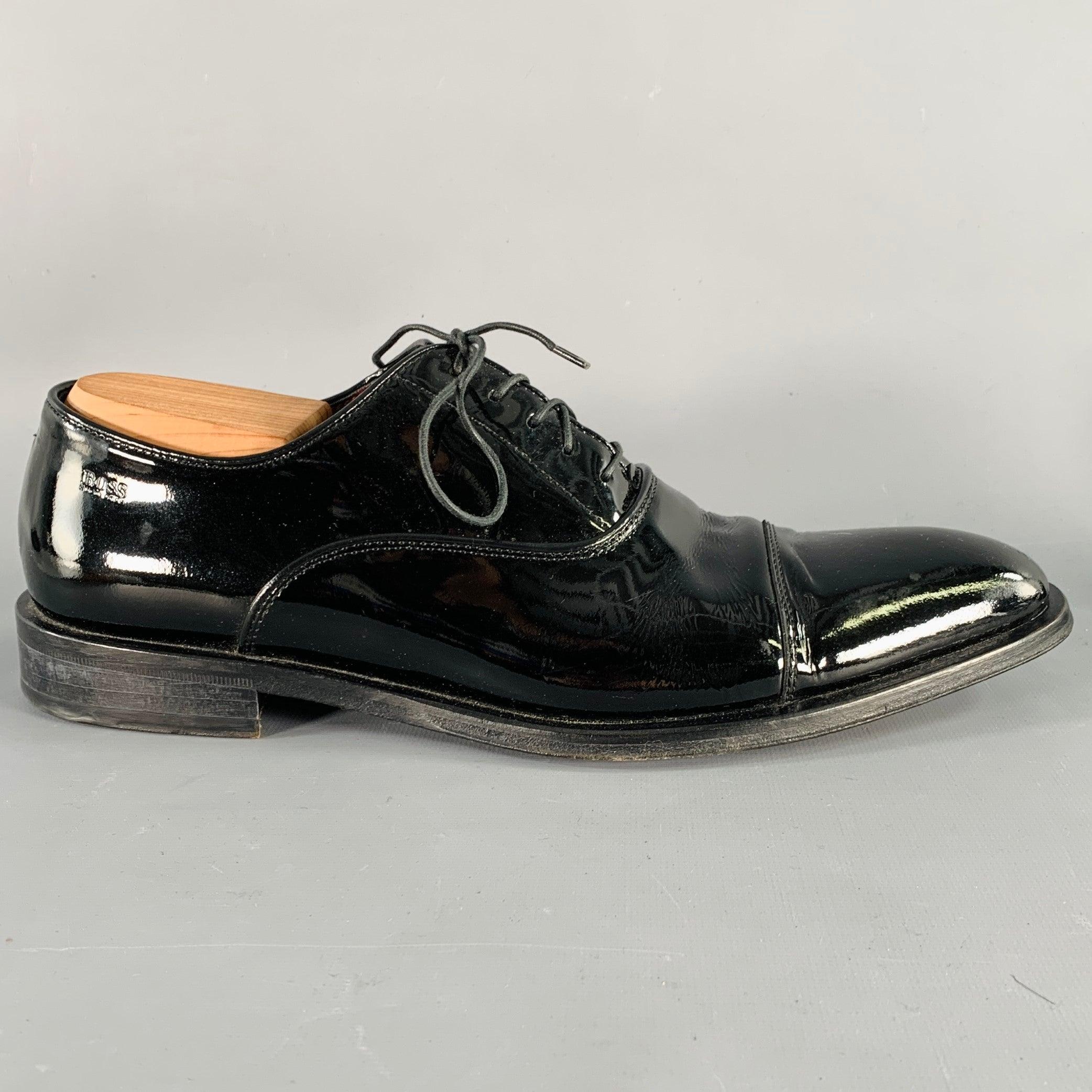 HUGO BOSS tuxedo formal shoes
in a black patent leather featuring an oxford style, cap toe, and lace-up closure. Shoe trees not included. Made in Italy.Good Pre-Owned Condition. Moderate creasing. 

Marked:   8.5Outsole:12.25 inches  x 4.25 inches