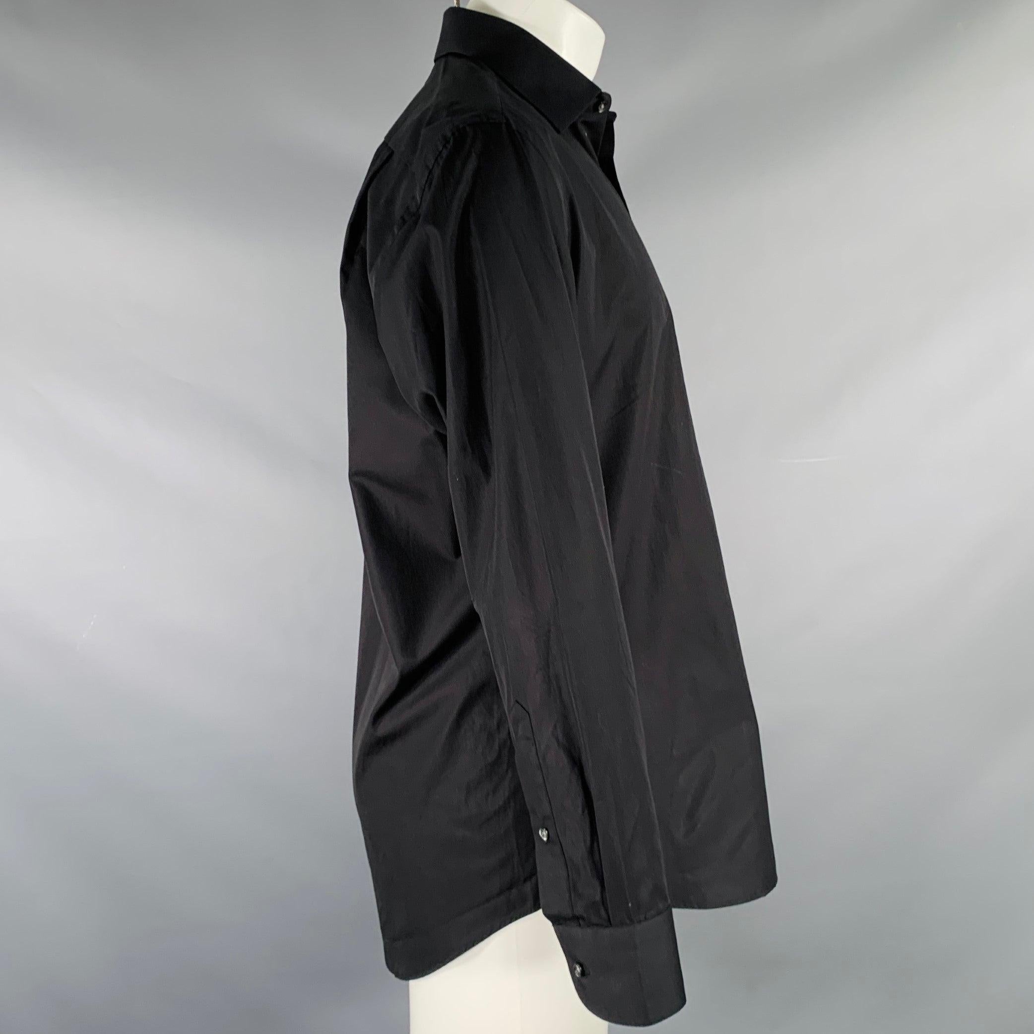 HUGO BOSS long sleeve shirt
in a black cotton woven fabric featuring curved cutaway collar, patch pocket, and button closure. Note: the sleeves are slightly uneven, please check measurements.Very Good Pre-Owned Condition. Minor marks on back.