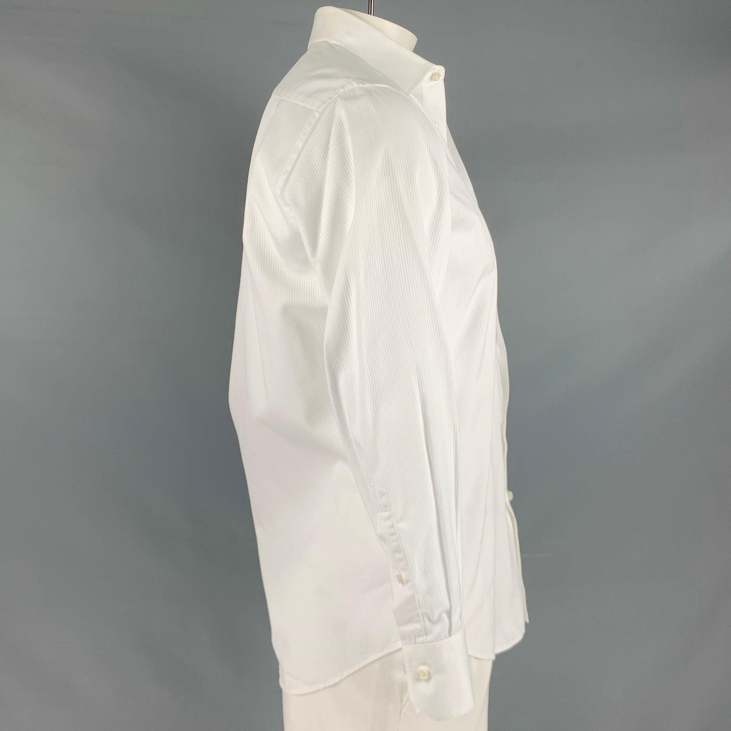 Langärmeliges Smokinghemd von HUGO BOSS aus weißem Baumwollstoff mit vertikalem Streifenmuster, einer Tasche und Knopfverschluss. Sehr guter gebrauchter Zustand. Geringfügige Mängel. 

Markiert:   15 / 32/33 

Abmessungen: 
 
Schultern: 16,5 Zoll