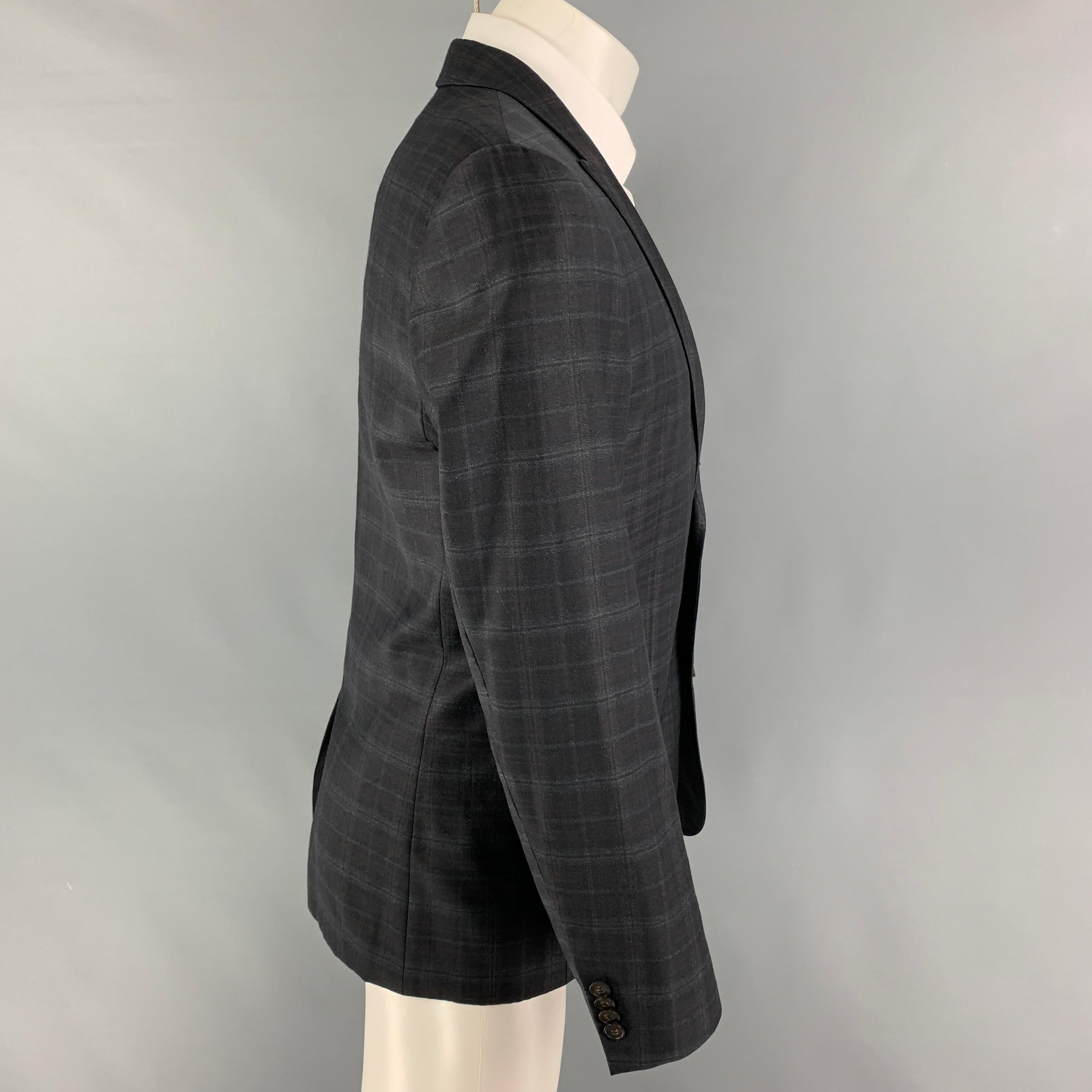 HUGO by HUGO BOSS sport coat comes in a grey & brown plaid virgin wool with a full liner featuring a peak lapel, slit pockets, single back vent, and a double button closure. 

Very Good Pre-Owned Condition.
Marked: 48/38
Original Retail Price: