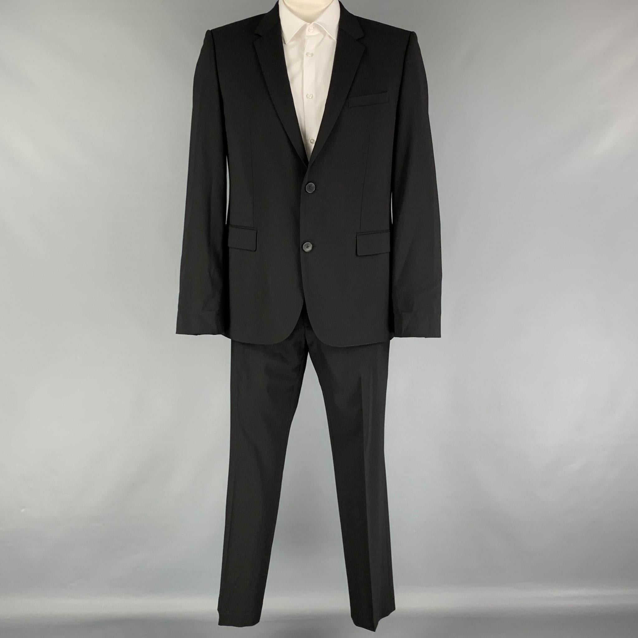 HUGO by HUGO BOSS suit comes in a black virgin wool with a full liner and includes a single breasted, double button sport coat with a notch lapel and matching flat front trousers.

Very Good Pre-Owned Condition. Discoloration at under arms.
Marked: