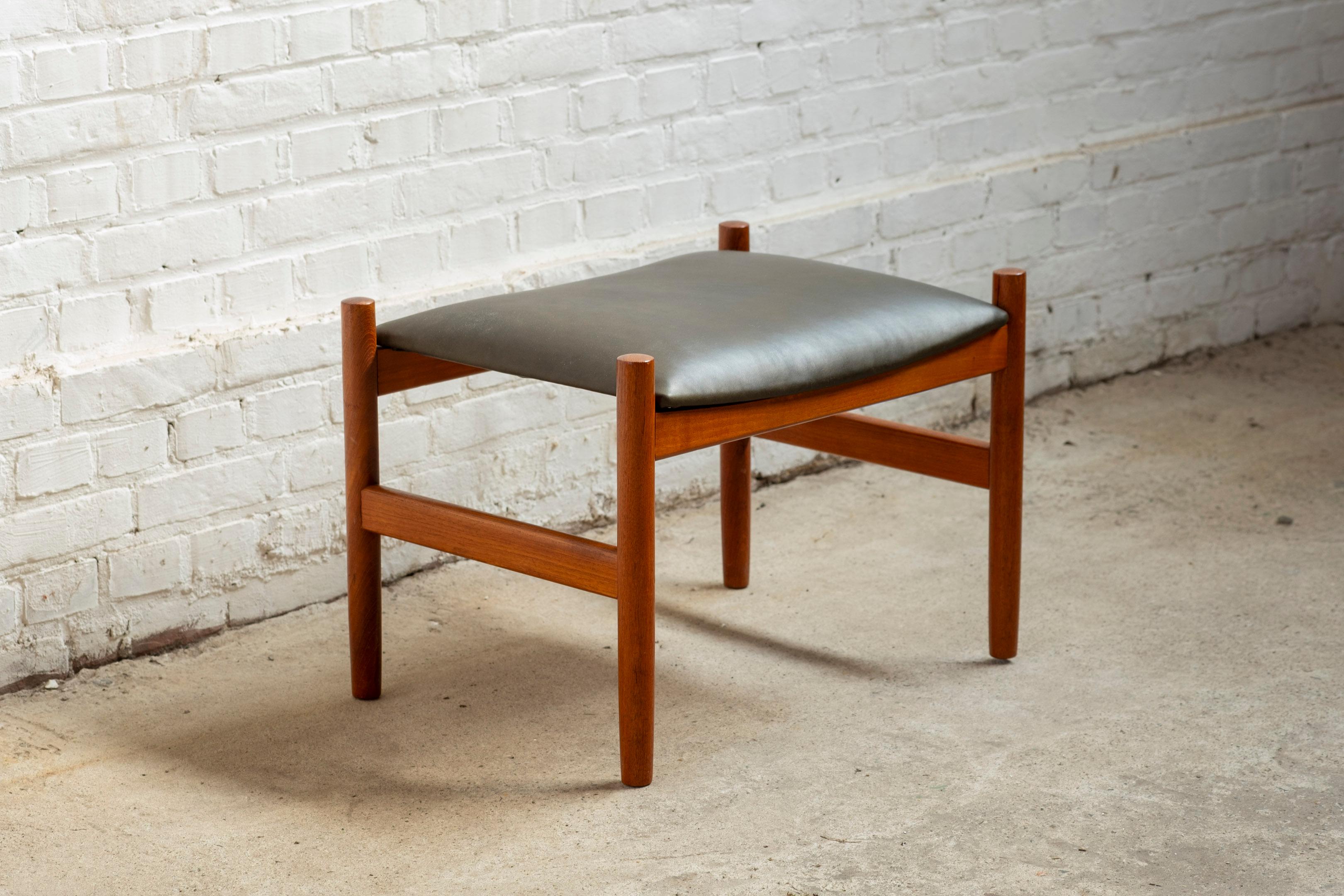 Tabouret ou ottoman en teck conçu par Hugo Frandsen, recouvert d'un cuir analine vert olive très foncé/proche du noir pour Spøttrup Møbler Danemark. Pièce idéale pour accompagner une chaise longue ou pour être utilisée comme tabouret.