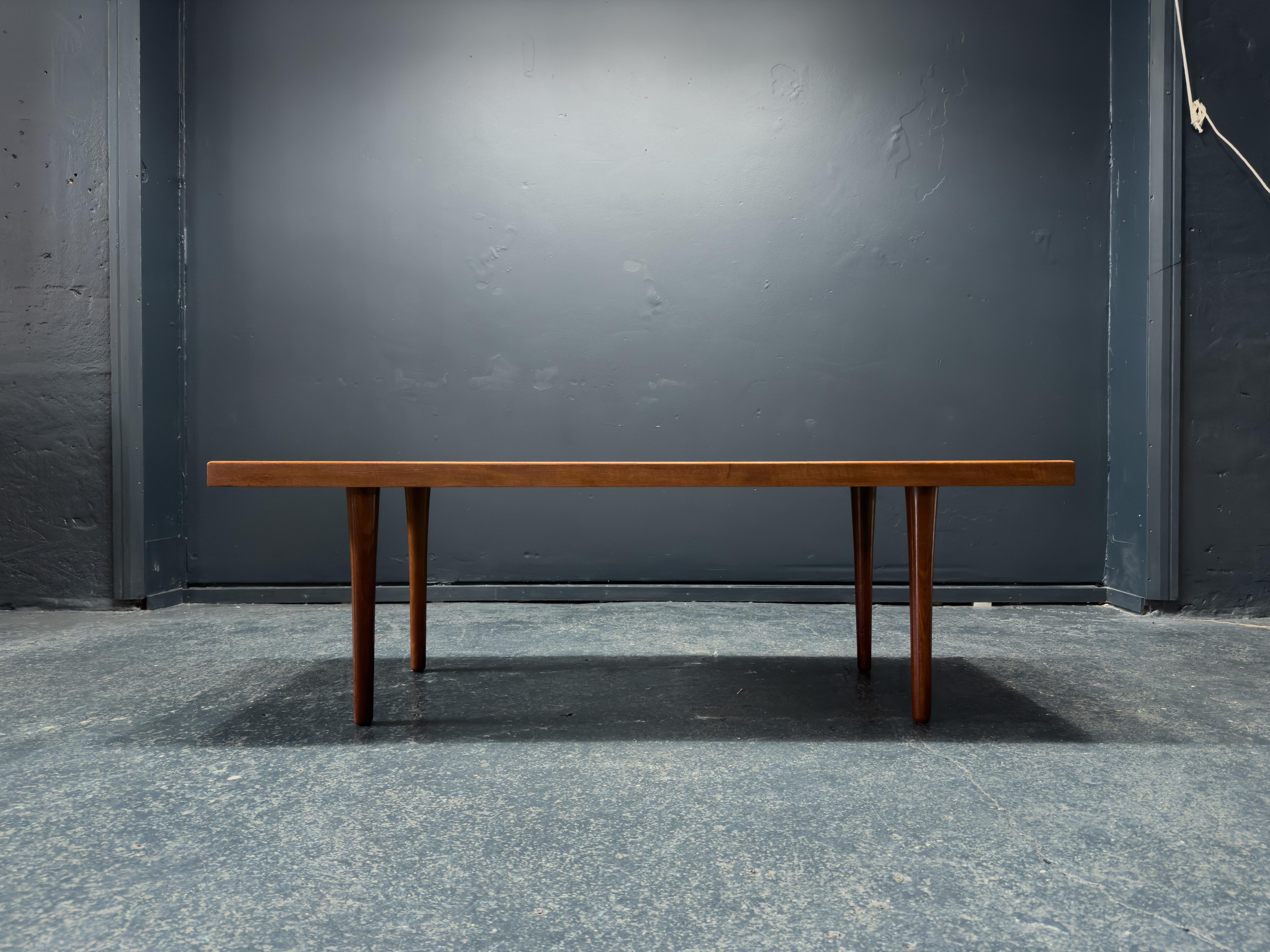 Créée par Hugo Jespersen dans les années 1970, cette magnifique table basse en teck est un parfait équilibre entre élégance et fonctionnalité. Les pieds effilés en teck sont magnifiquement sculptés et le plateau de la table est d'une finition