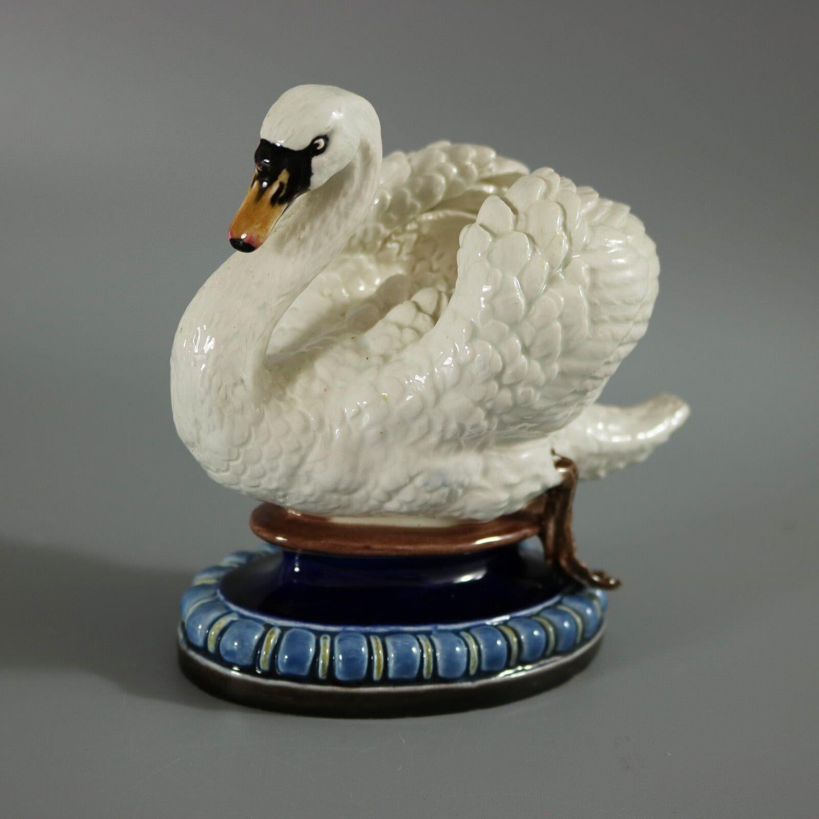 Hugo Lonitz Majolica figure which features a swan. Colouration: white, blue, brown, are predominant. The piece bears maker's marks for the Lonitz pottery. Bears a pattern number, '1767'.