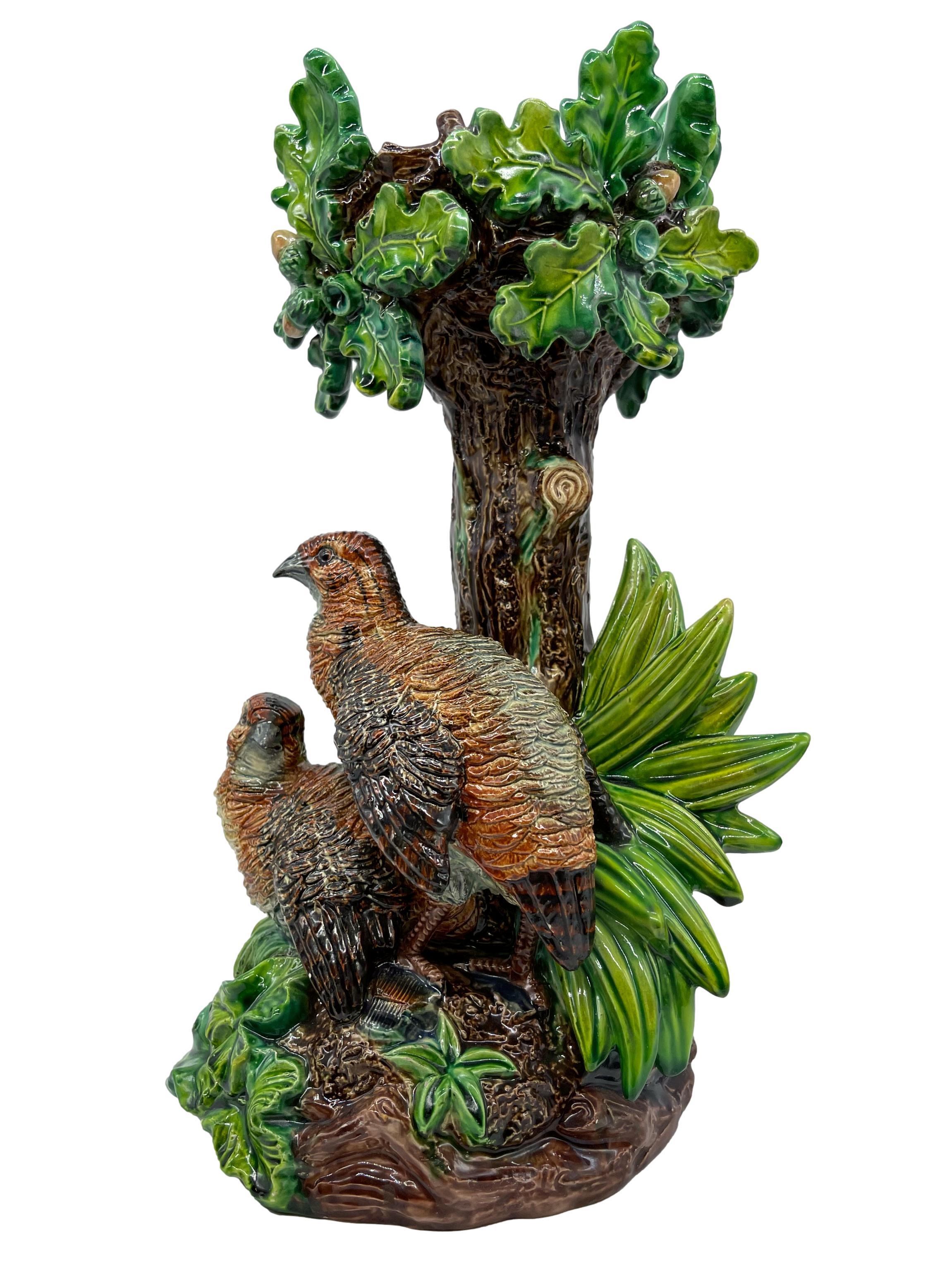 Hugo Lonitz Majolica figural table Jardinière stand, naturalistically molded as an oak tree, with a pair of partridges nesting among bulrushes and grasses, on a rustic mound-form, log and rockwork base, the reverse with impressed marks: Hugo Lonitz