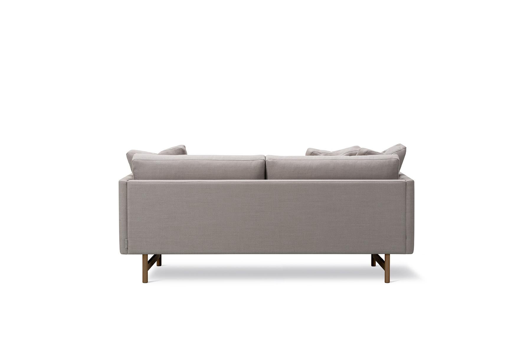 Hugo Passos Calmo sofa 80 – 2-seater – Wood base is simple and serene in this expansive 3-seater Calmo sofa, where straight lines converge with discrete curved details. Comfy cushions complete the picture in this understated expression of elegance.