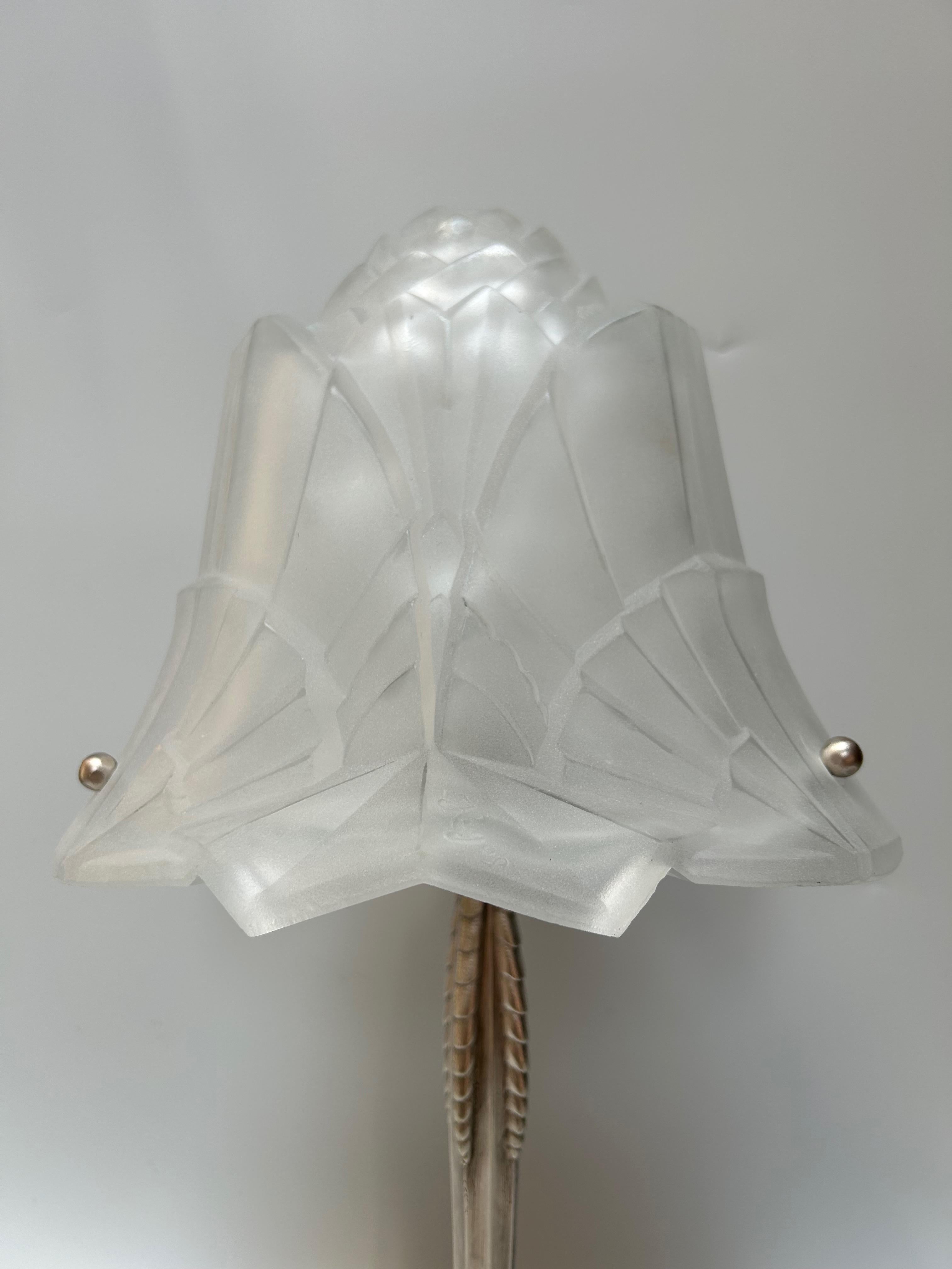 Art Deco lamp circa 1930.
Silver-plated bronze base.
Geometric-shaped molded glass shell.
Hugues molded signature.
In perfect condition.
Electrified.

Total height: 46 cm
Base diameter: 12 cm
Shell diameter: 25 cm
Weight: 3,5 kg
