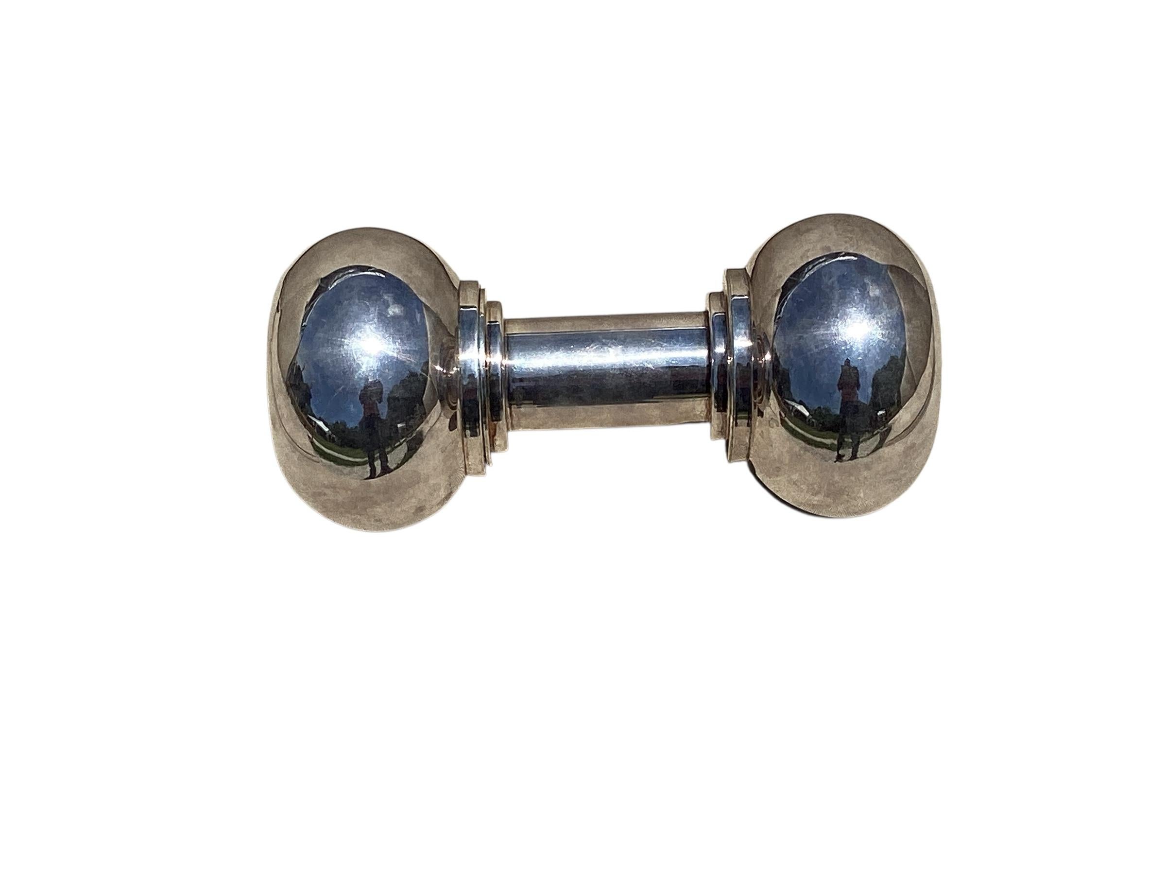 A silver-plated cocktail shaker in the form of a dumbbell. Manufactured by Hukin and Heath around 1930. The dumbbell unscrews to reveal a strainer and a reservoir to hold your beverage of choice. Silver plating is still in good condition with