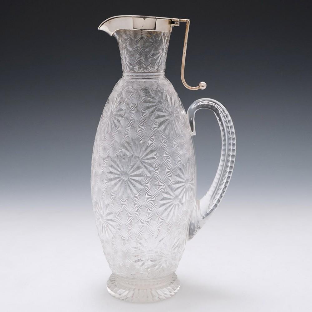 Heading : Stevens and Williams claret jug
Date : 1893
Period : Victoria
Origin : Stourbridge
Colour : Clear
Stopper : Hukin and Heath sterling silver hallmarked in Birmingham in 1893.
Neck : Terraced collar.
Body : All over petal cut pattern of