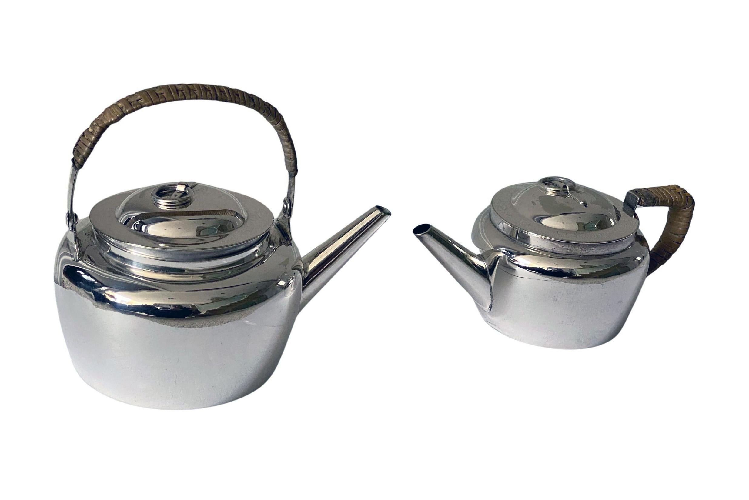 Bollitore e teiera in argento di Hukin and Heath Christopher Dresser Inglese C.C. 1884. Semplice design ovoidale con maniglia pieghevole per il bollitore e terminali ad anello incernierati per entrambi. Questi oggetti sarebbero stati utilizzati come