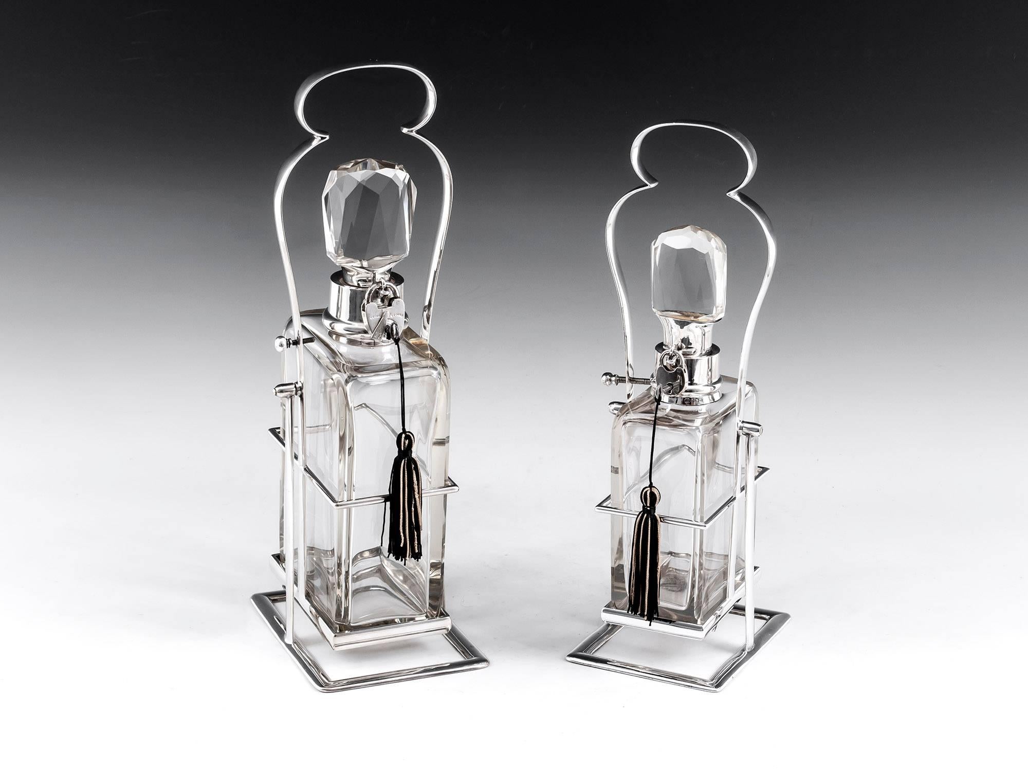 Rare pair of stylish Hukin & Heath decanters within their own carrying frames. The smaller is hallmarked Birmingham 1912 Hukin & Heath on the neck and stopper, the larger hallmarked Birmingham 1910. The fabulous frames have registered design stamps,