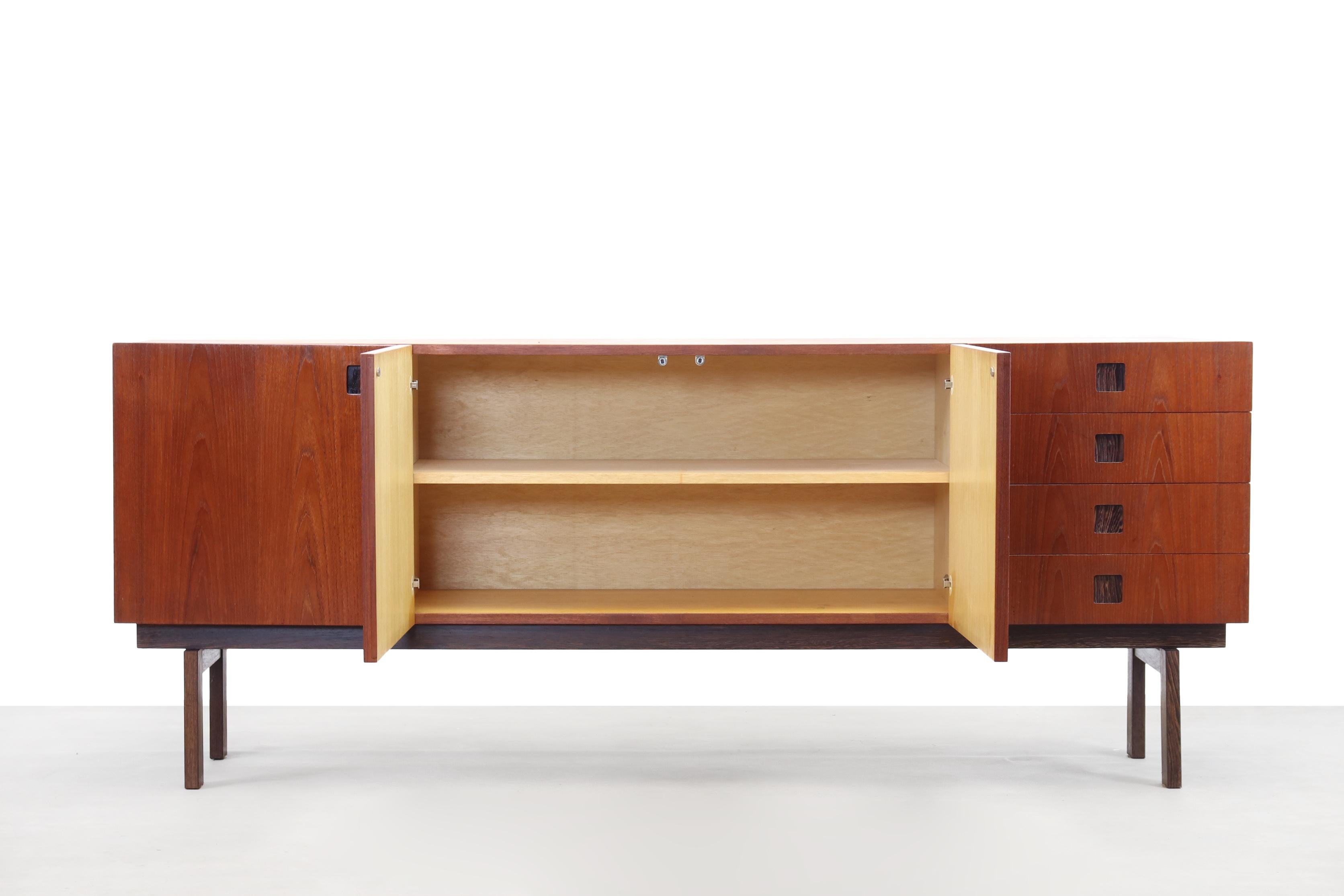This is a very beautiful and elegant Dutch design sideboard made by Hulmefa. This sideboard comes from the Propos series, made in the late 1950s-1960s. It is veneered in teak with wenge details, such as the deep-set square handles. The sideboard
