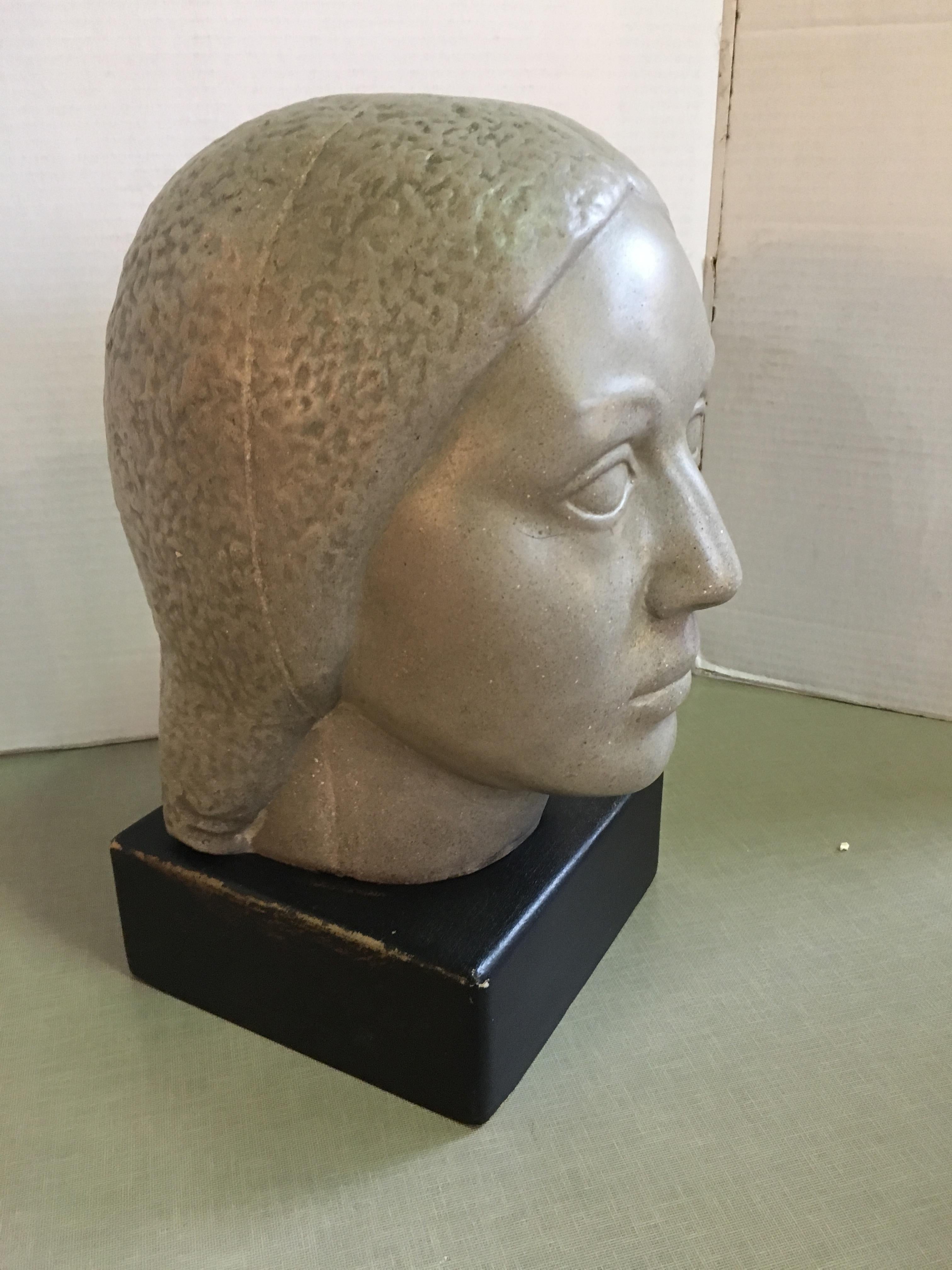 A limestone head of a woman sculpture on a base by Humbert Albrizio.