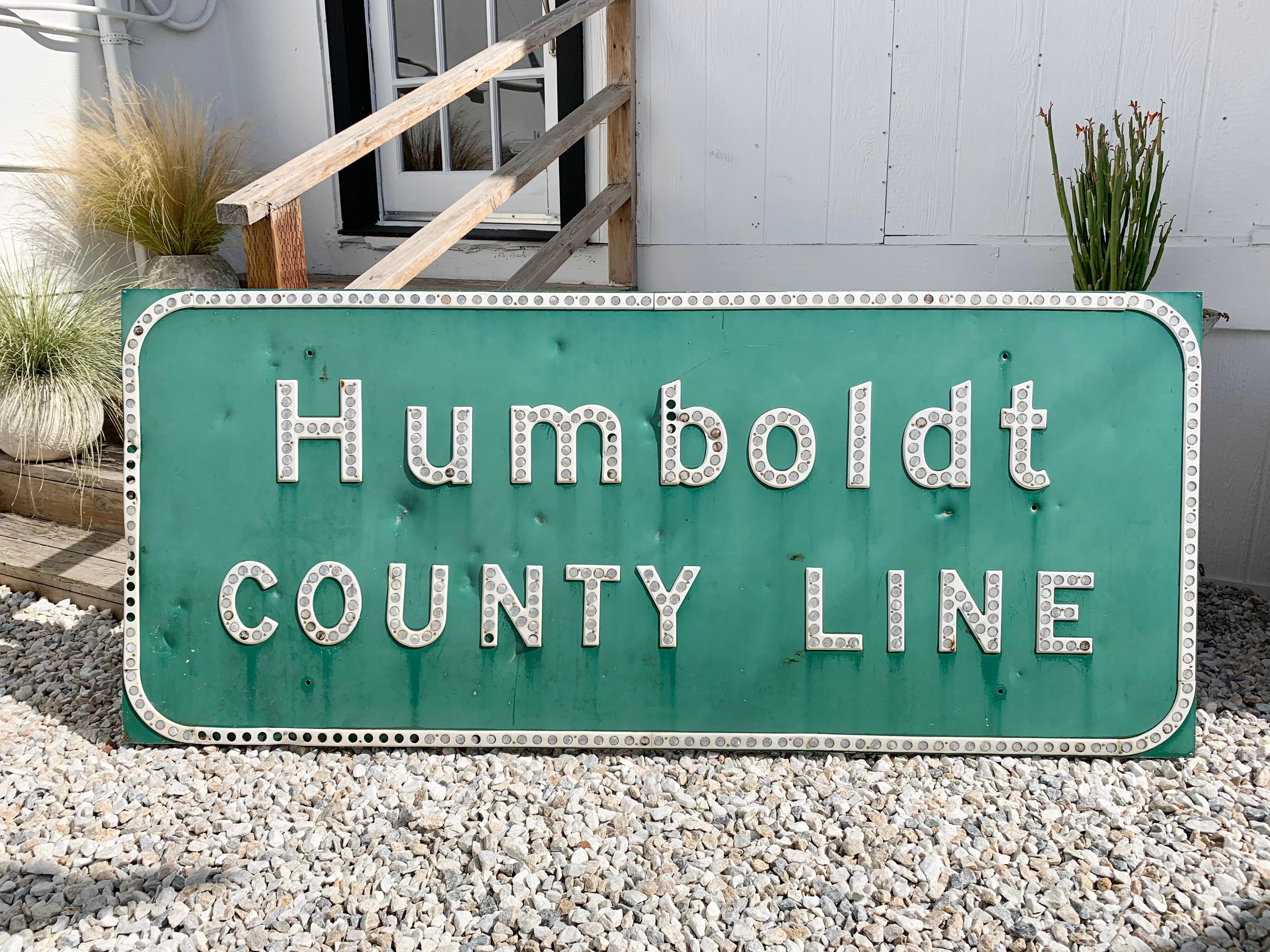 Panneau d'autoroute de Humboldt County Line en Californie du Nord. Fabriqué en 1965. Une belle pièce de l'histoire du Marijuana et de l'Amérique des transports. 2 mètres de large. Panneau en acier vert avec lettrage blanc et réflecteurs en forme