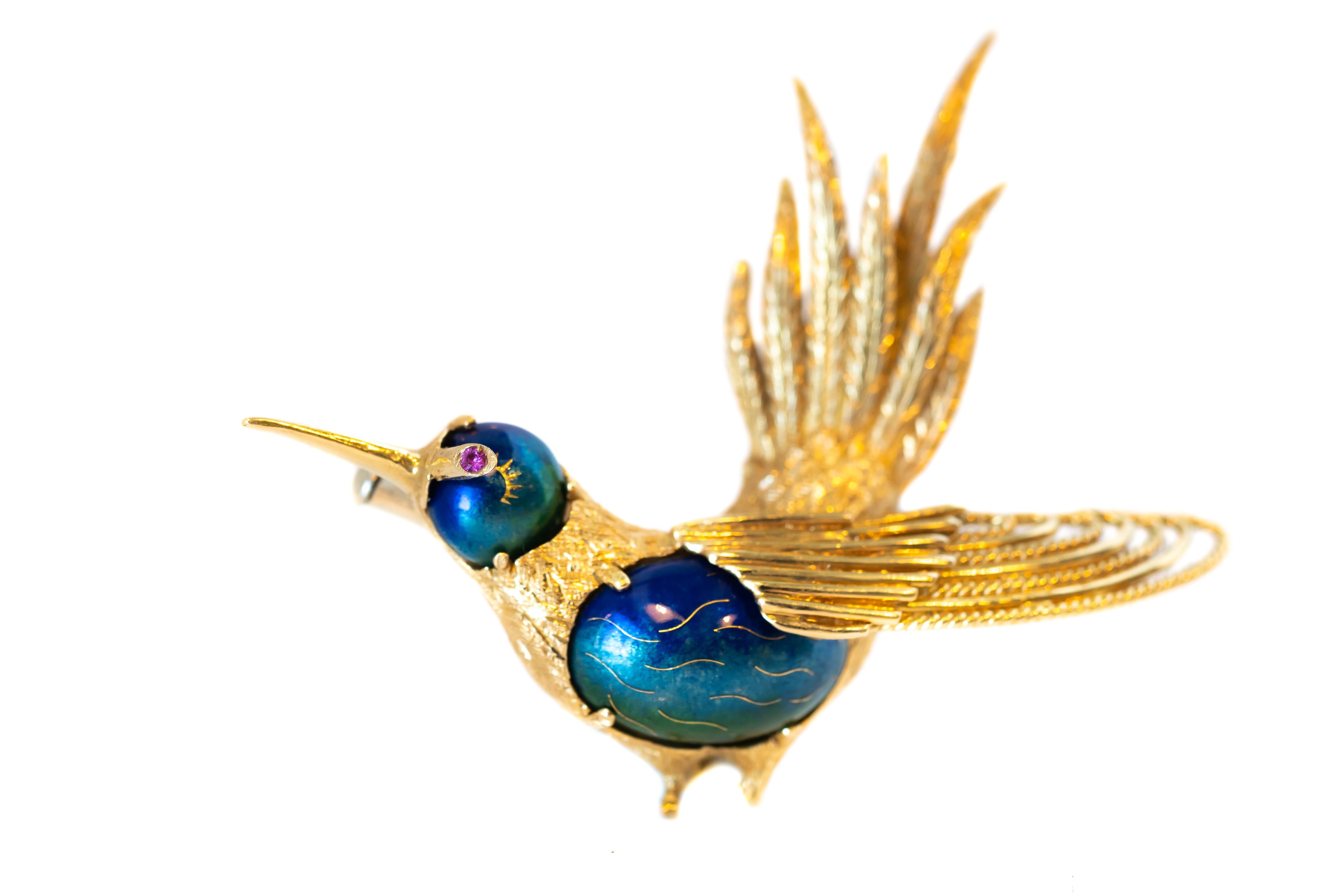 18 Karat Yellow Gold Hummingbird Pin from the 1950s!
This stunning brooch is made in Italy. 

Features include:
- Mediterranean Deep blue green enamel and red ruby eye
- richly textured gold and finely detailed feature texture
- slim Golden Beak,