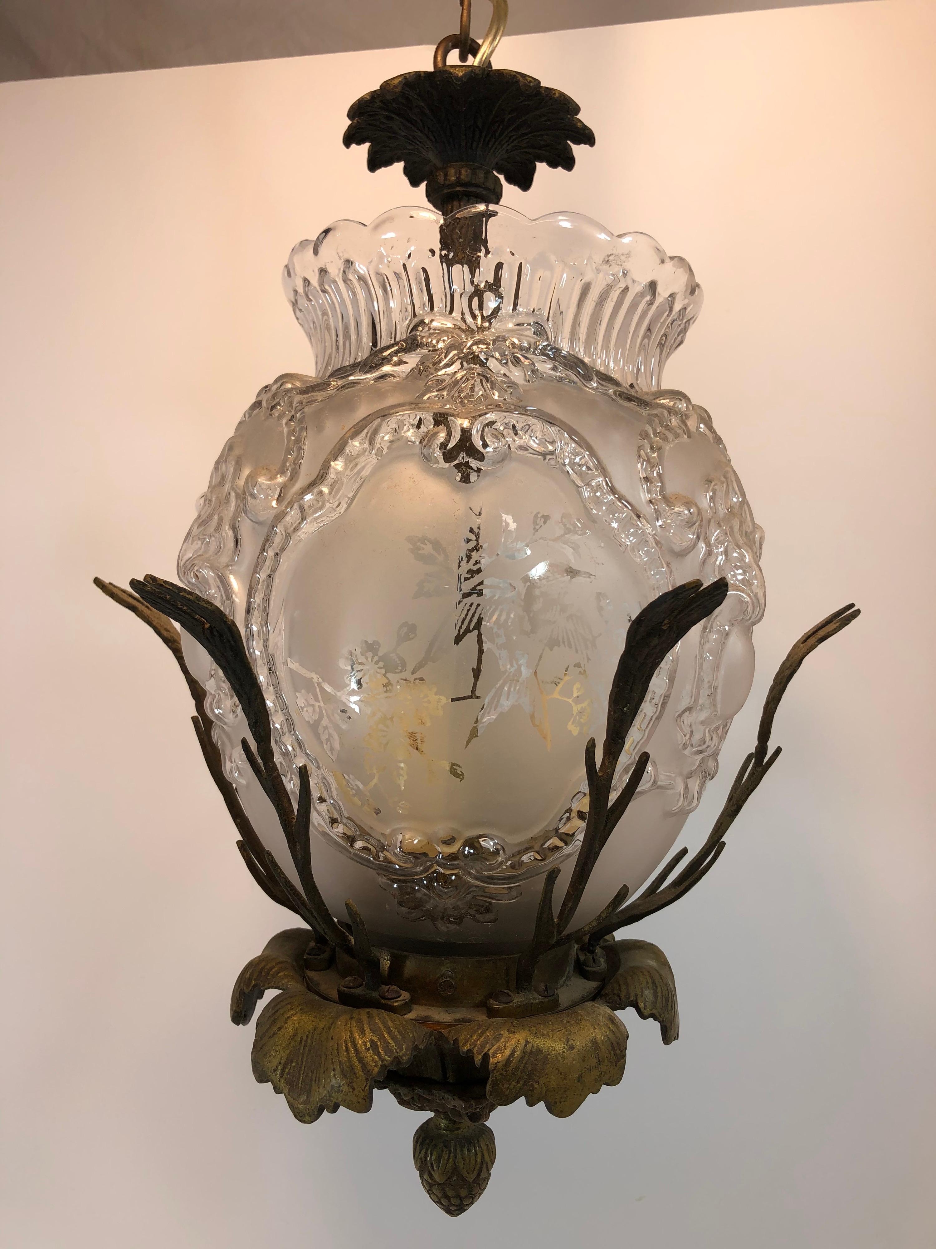 Hummingbird chandelier with cast bronze frame and pressed, etched glass shade. Three candelabra sockets. Looks to be rewired. Hummingbirds are on three sides of the glass with nice detail to the glass. Hard to capture detail in photos. Without chain