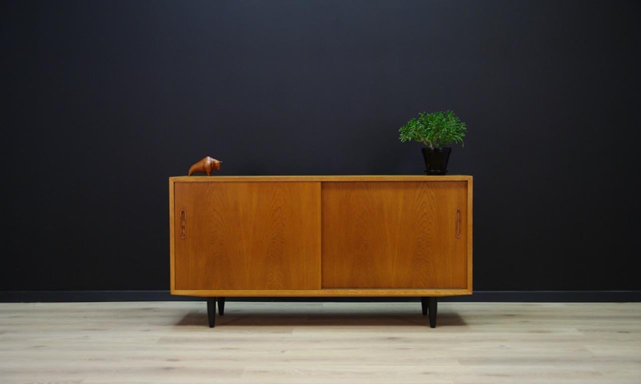 A vintage cabinet from the 1970s. A Minimalist form designed by Poul Hundevad, produced in the Hundevad & Co. manufactory. Finished with ash veneer. A spacious interior with many shelves and drawers behind the sliding door. Preserved in good