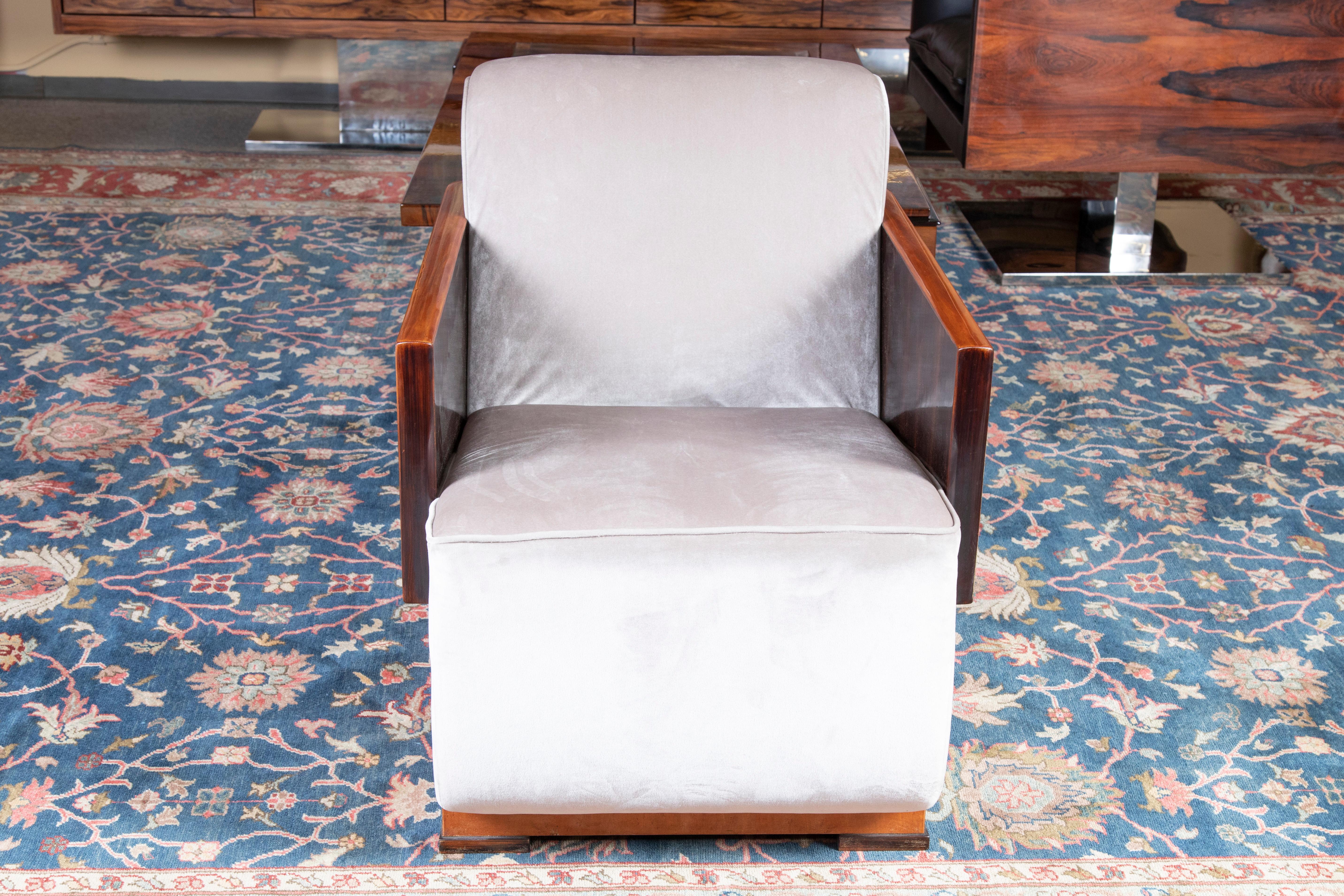 Armchairs are made out of walnut wood and re-upholstered in a light velvety fabric. Arms of the chair is made out of solid piece of wood. On the side beautiful woodgrain is visible. Chair rests on the 4 square wooden legs. 
Back of the chair is