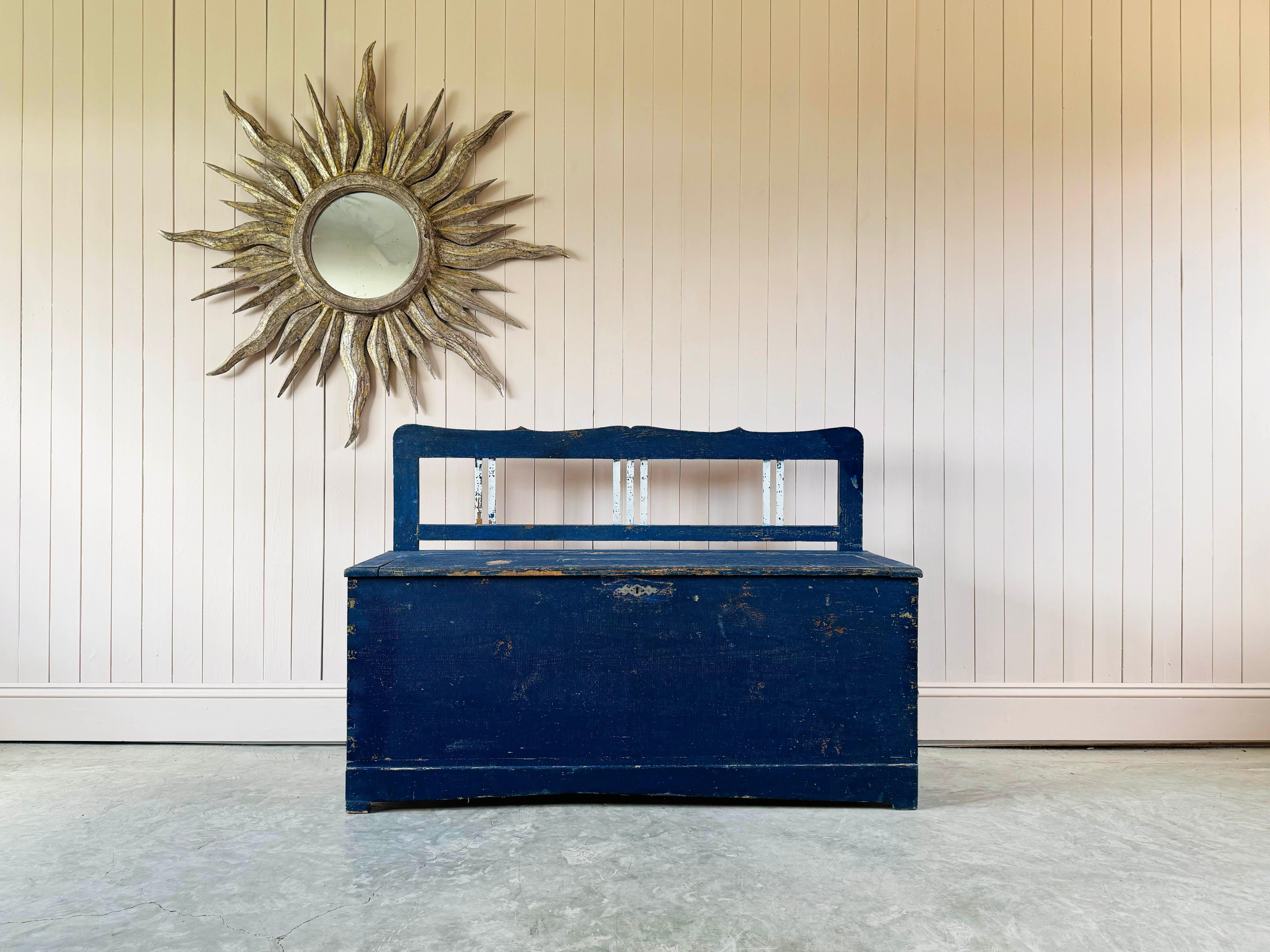 This settle or bench is early 20th Century.  Wonderful natural colours and patina.  It's a really useful and fun piece of furniture. Lots of useful storage inside would look great in a hallway or even a kids bedroom, with it's vibrant blue and