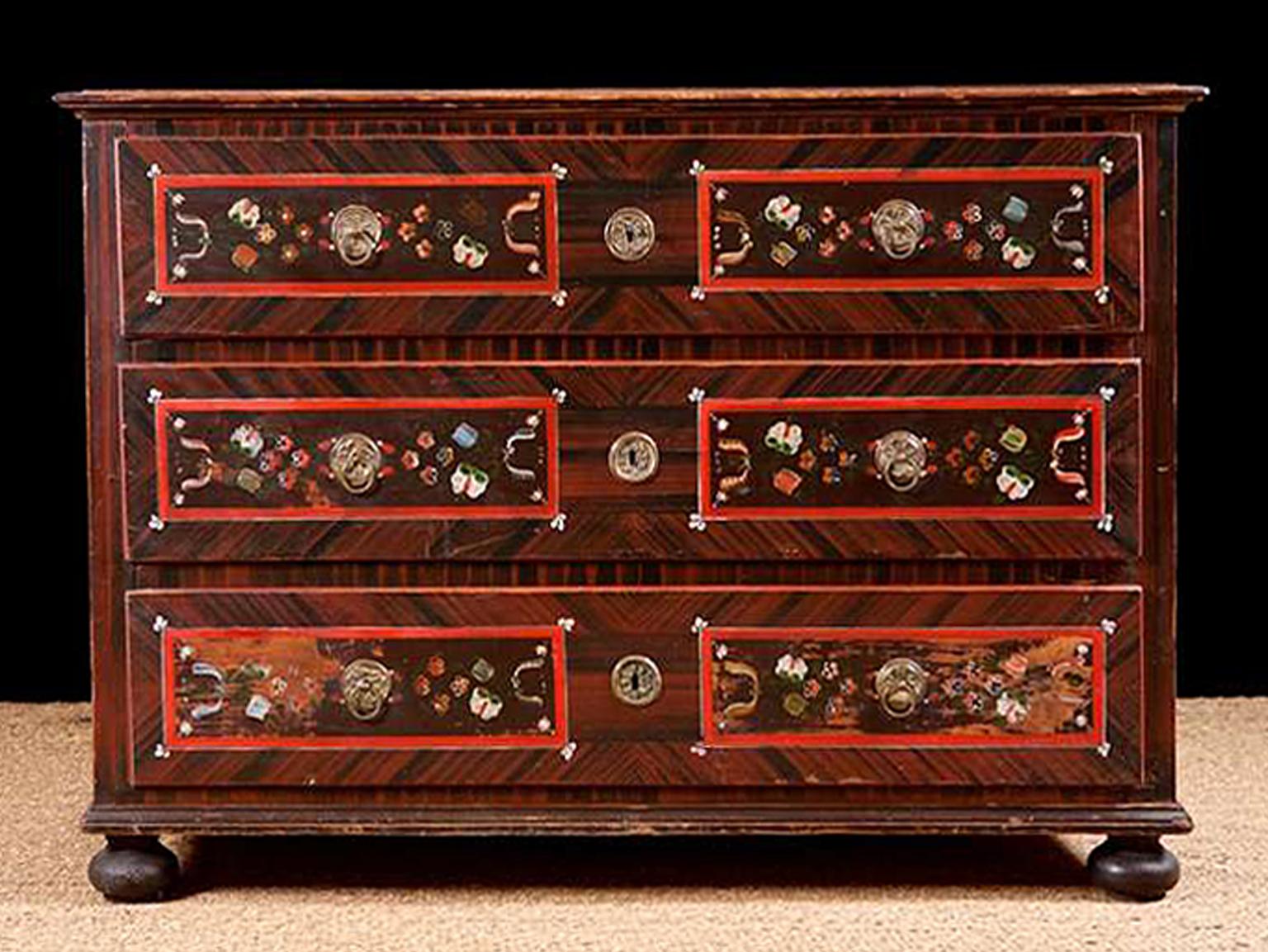 A charming dowry or wedding chest with the original folk-art, painted finish. Features tooling techniques with floral designs on the painted panels over the top and front of each of the three drawers, using a palette consisting of red and black