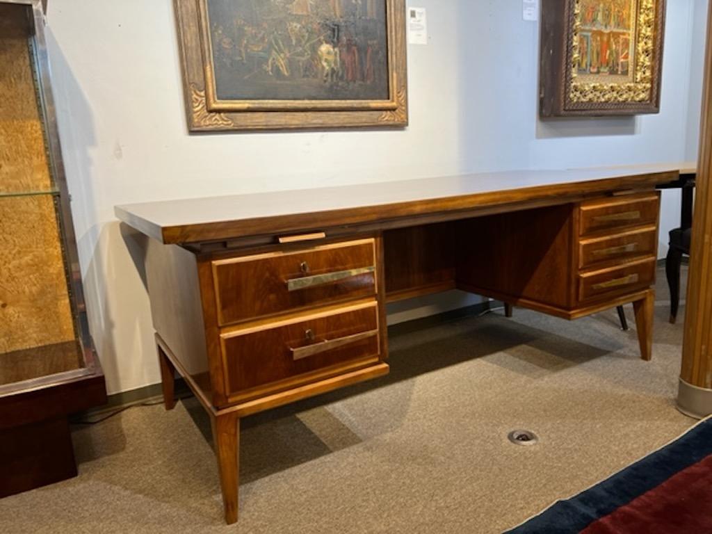 Desk is made out of beautiful walnut wood, displaying mesmerizing wood grain on the table top. There are 2 keyed spacious drawers on the left side and 3 smaller drawers on the right side of the desk. On each side there are wood extensions that could