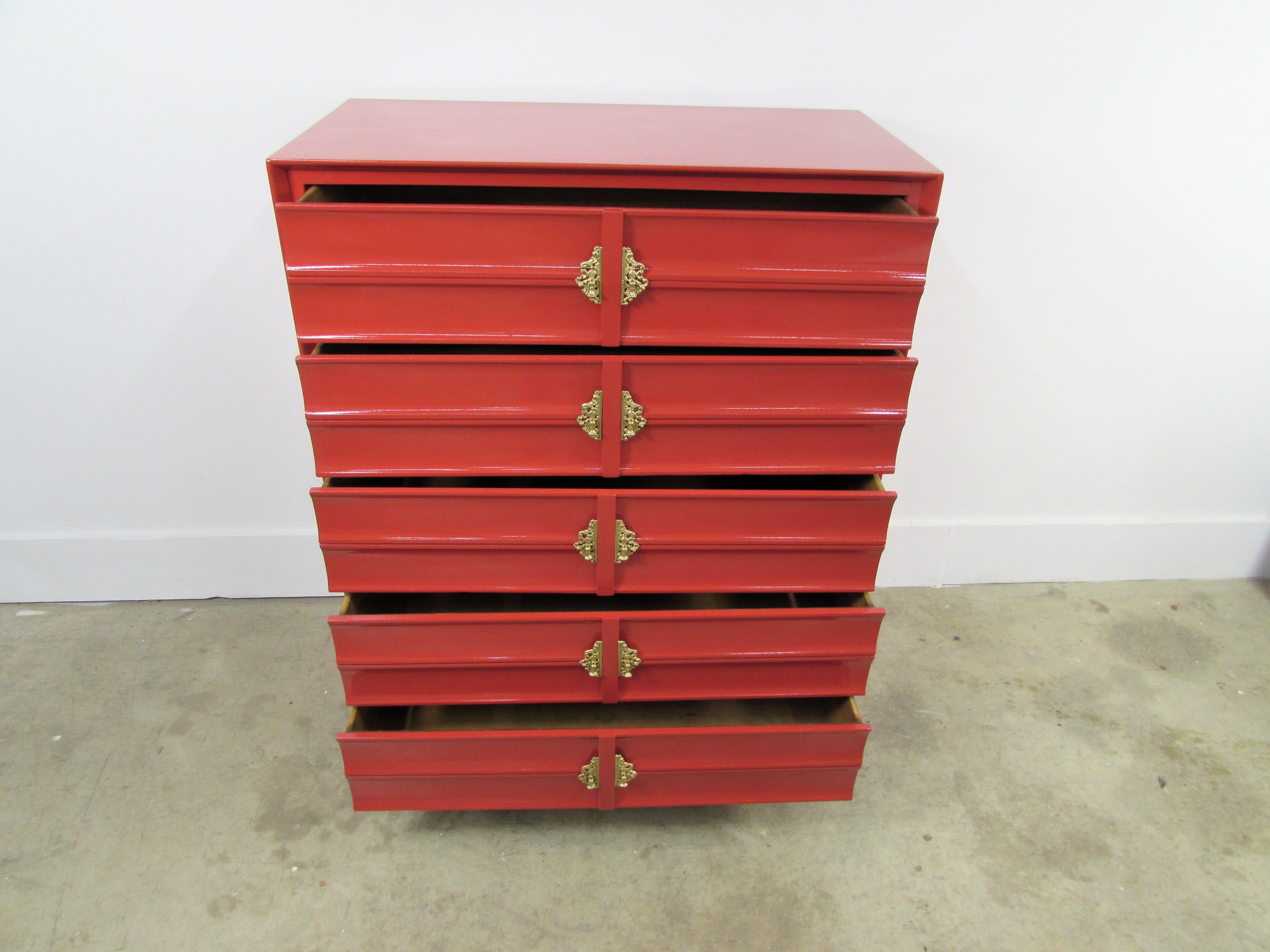 Hungerford rave red lacquered five dove tail-drawer chest customized in-house, drawers are encased and adorned in Chinoiserie brass under gold hardware, ending in brass cap feet.
     