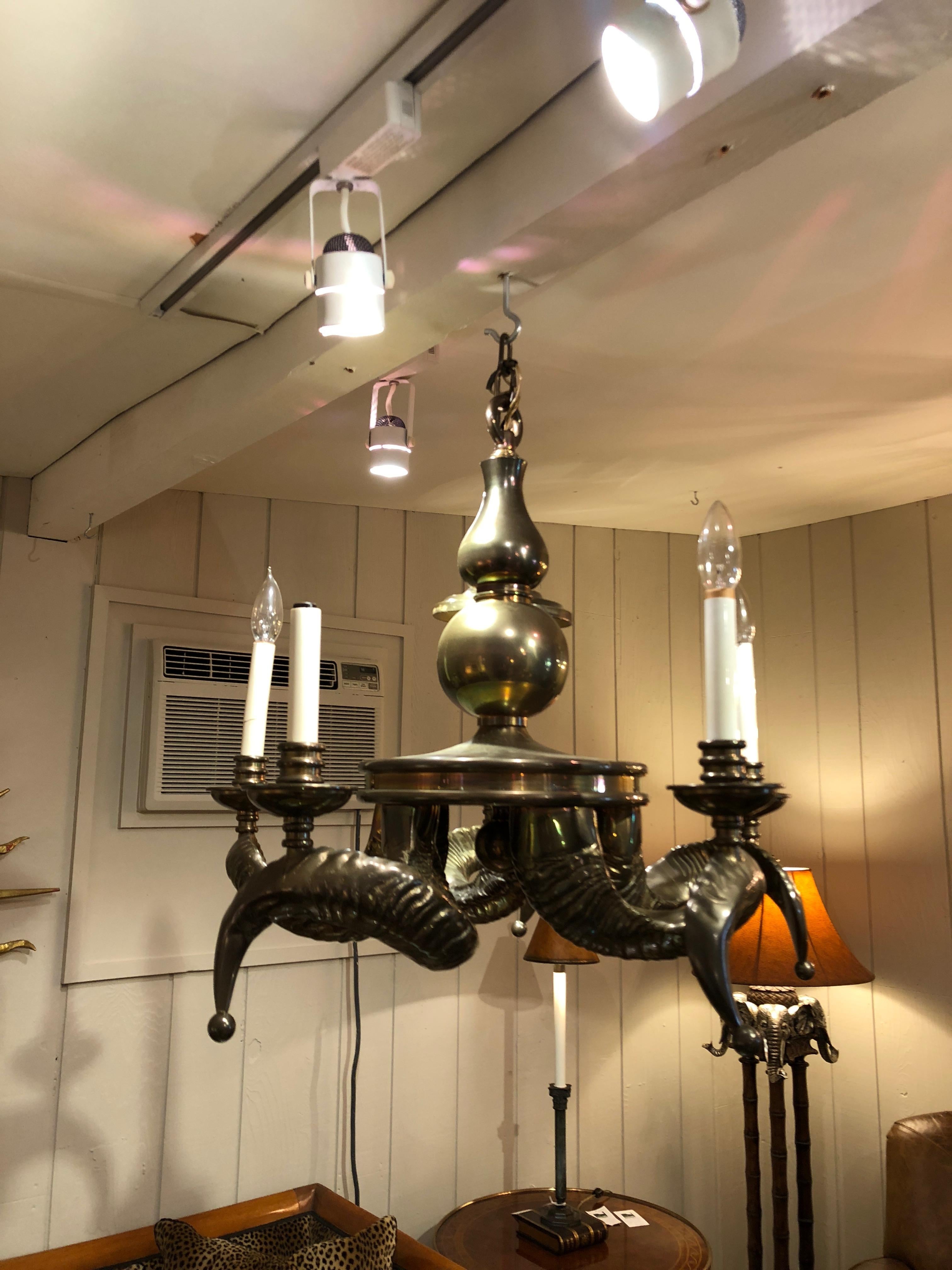 Eine unglaubliche Vintage und schwer massivem Messing Widder Horn Kronleuchter mit einer Schleife finial, die zu einem kurvigen Baluster auf einer runden Plattform befestigt ist. Fünf wunderschön gegossene Widderhörner erstrecken sich von der