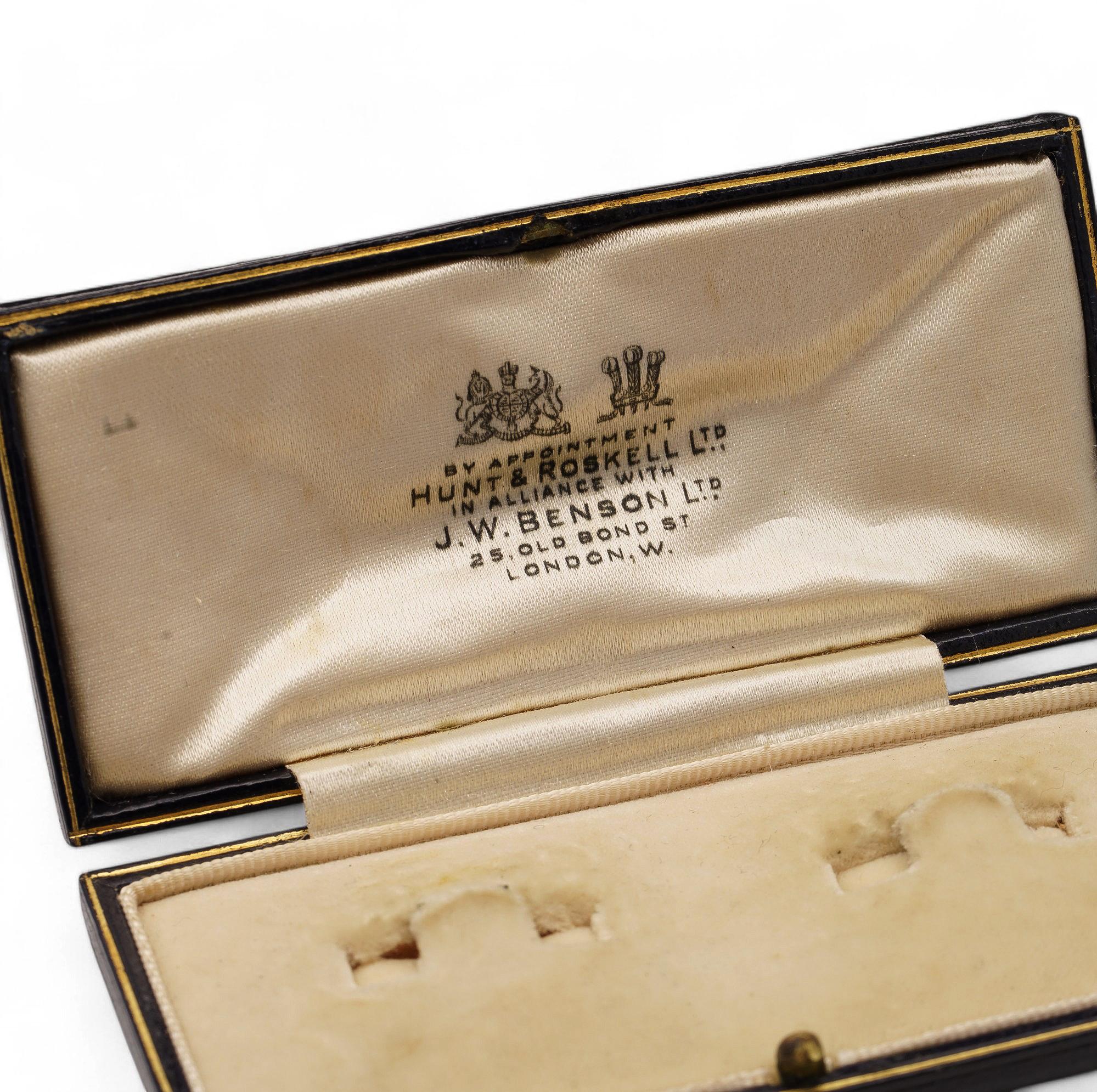 A rectangular cufflinks box with a sleek and polished exterior, complemented by a velvet and satin interior. The branding on the lid signifies royal connections.

This vintage cufflinks box by Hunt & Roskell exudes sophistication. The velvet