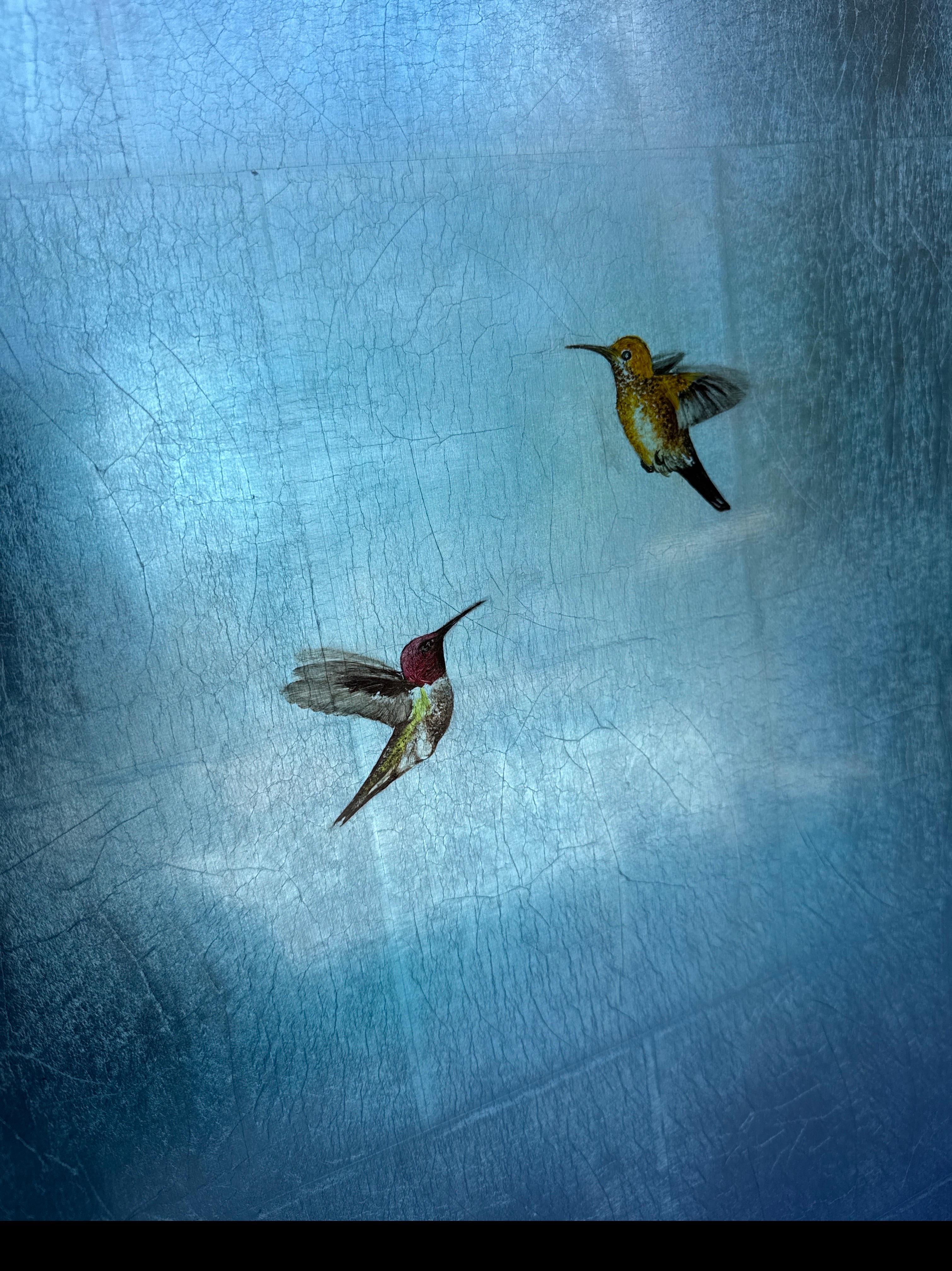 Blue Bliss IV di Carolyn Reynolds cattura l'eleganza della natura con due colibrì in volo su un sereno sfondo azzurro. La ricca tonalità evoca la calma, mentre la foglia d'argento aggiunge un effetto scintillante ed etereo che riflette la luce in