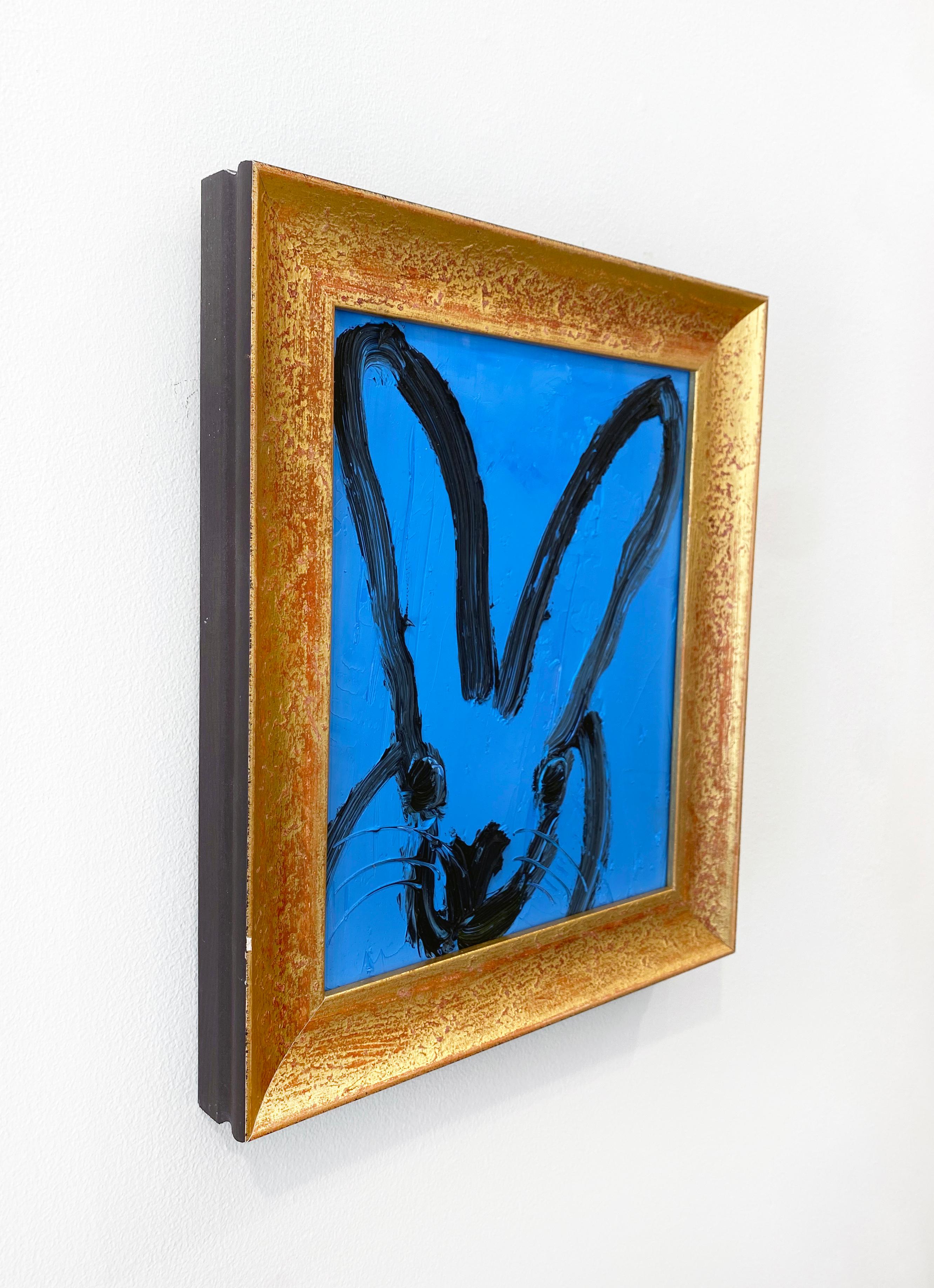 'Brandon' by Hunt Slonem, 2021. Oil on wood, 10 x 8 in. Framed size is 12.5 x 10.5 in. This painting features Slonem's signature bunny outlined in black on a bright blue background. This charming bunny features an expressive face with large eyes and