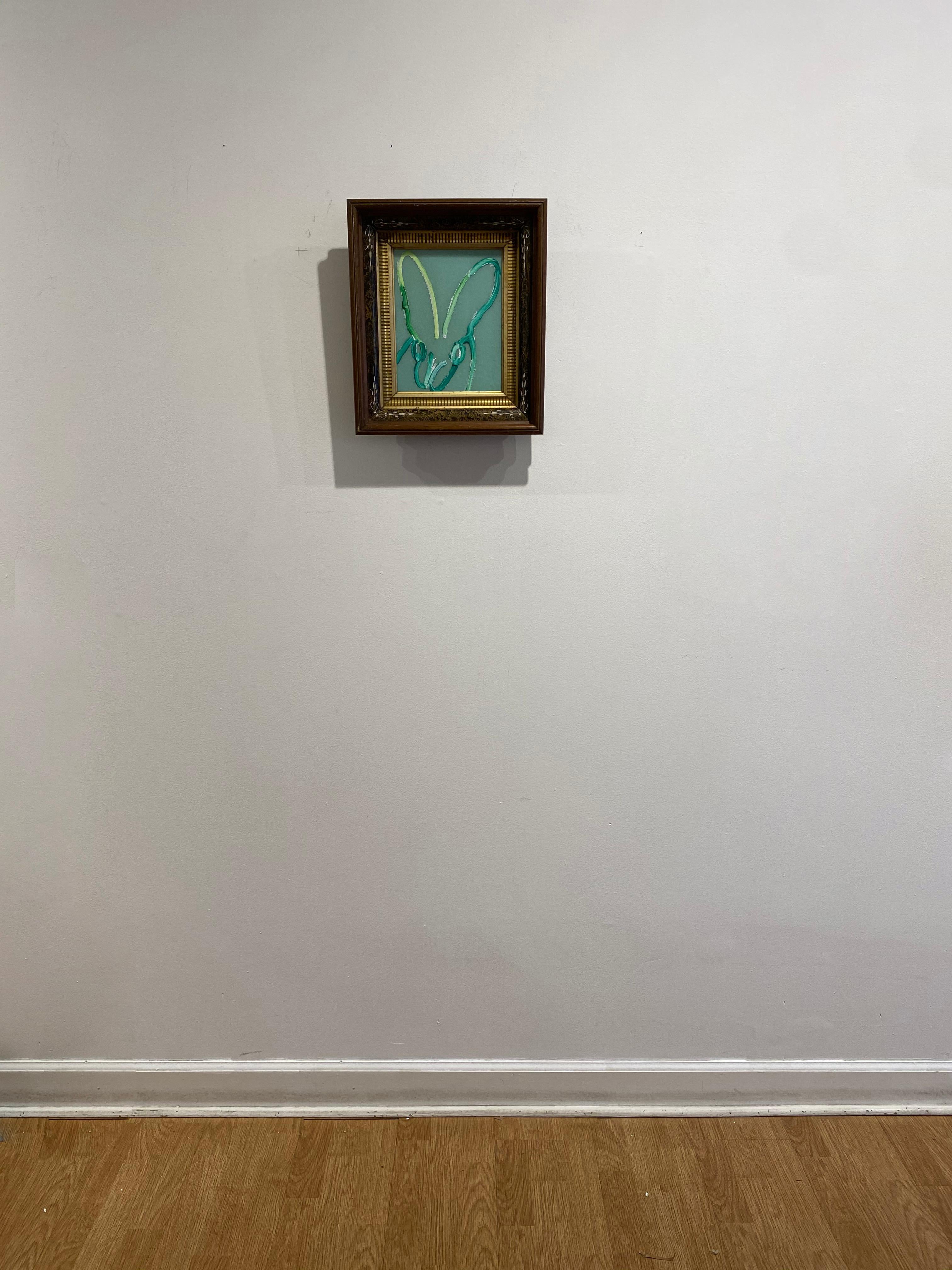 'Untitled' by Hunt Slonem, 2020. Oil and acrylic with diamond dust on wood, 10 x 8 in.  Framed size is 15 x 13.5 in. This painting features Slonem's signature bunny outlined in turquoise, yellow and white on a shiny, diamond dust turquoise