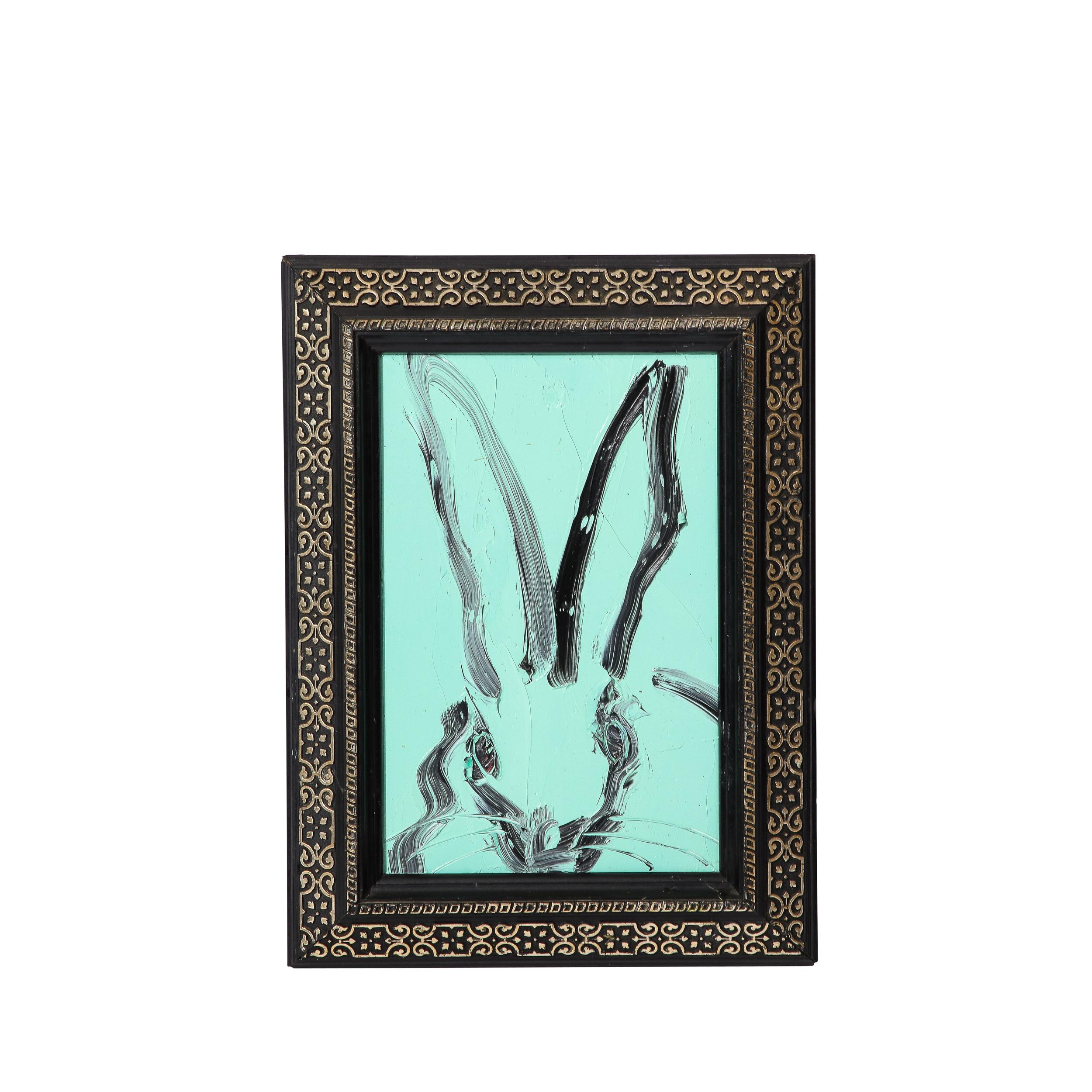 This whimsical and sophisticated painting was realized by the esteemed contemporary painter, Hunt Slonem in 2017. This piece features a lovely background in light blue green with deftly rendered brush strokes depicting a rabbit in black paint.  The