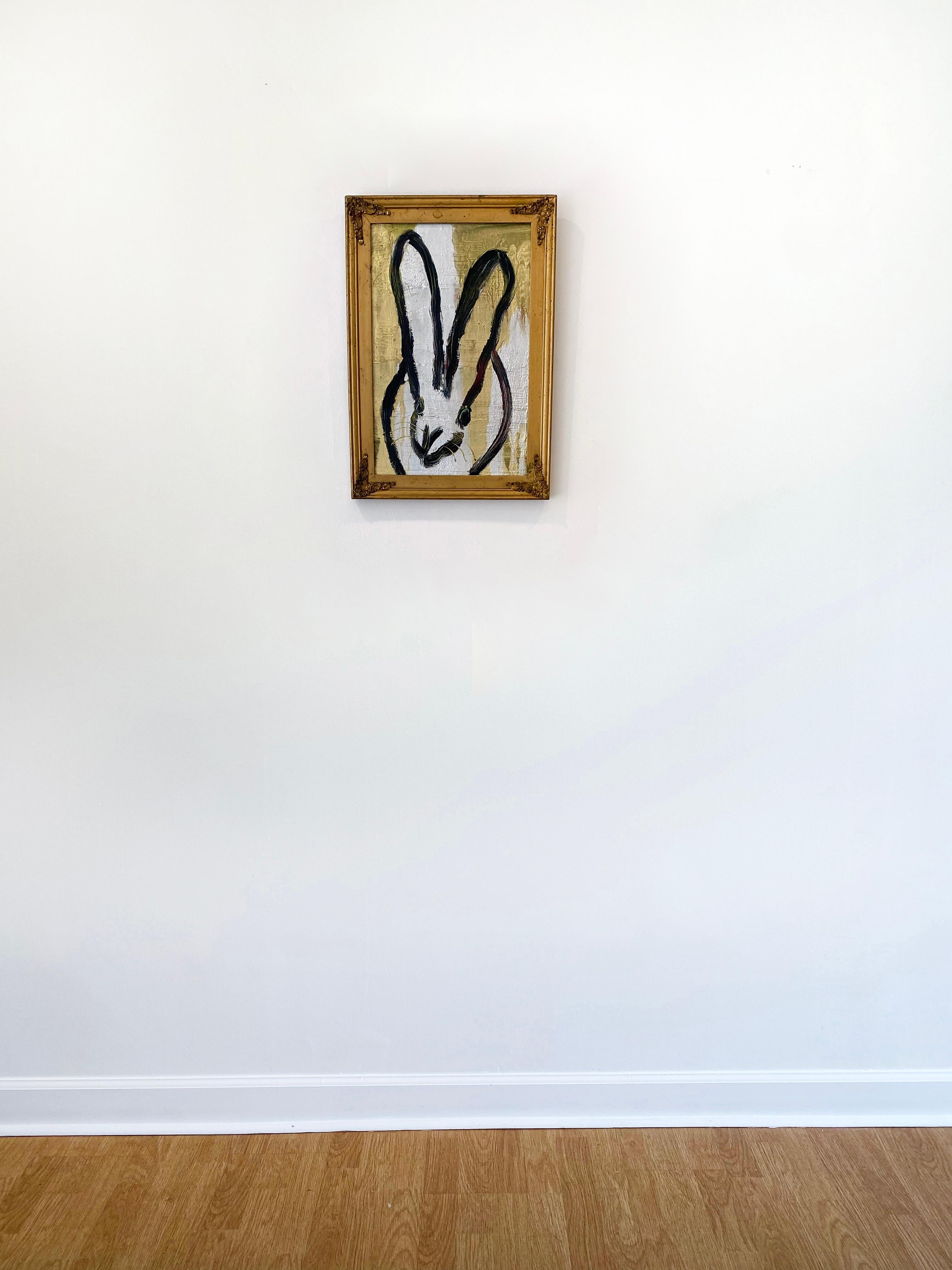 'Harold' by Hunt Slonem, 2021. Oil on wood, 15 x 10 in. Framed size is 18 x 13 in. This painting features Slonem's signature bunny outlined in black on a metallic gold and silver background. This expressive bunny features long slender ears and a