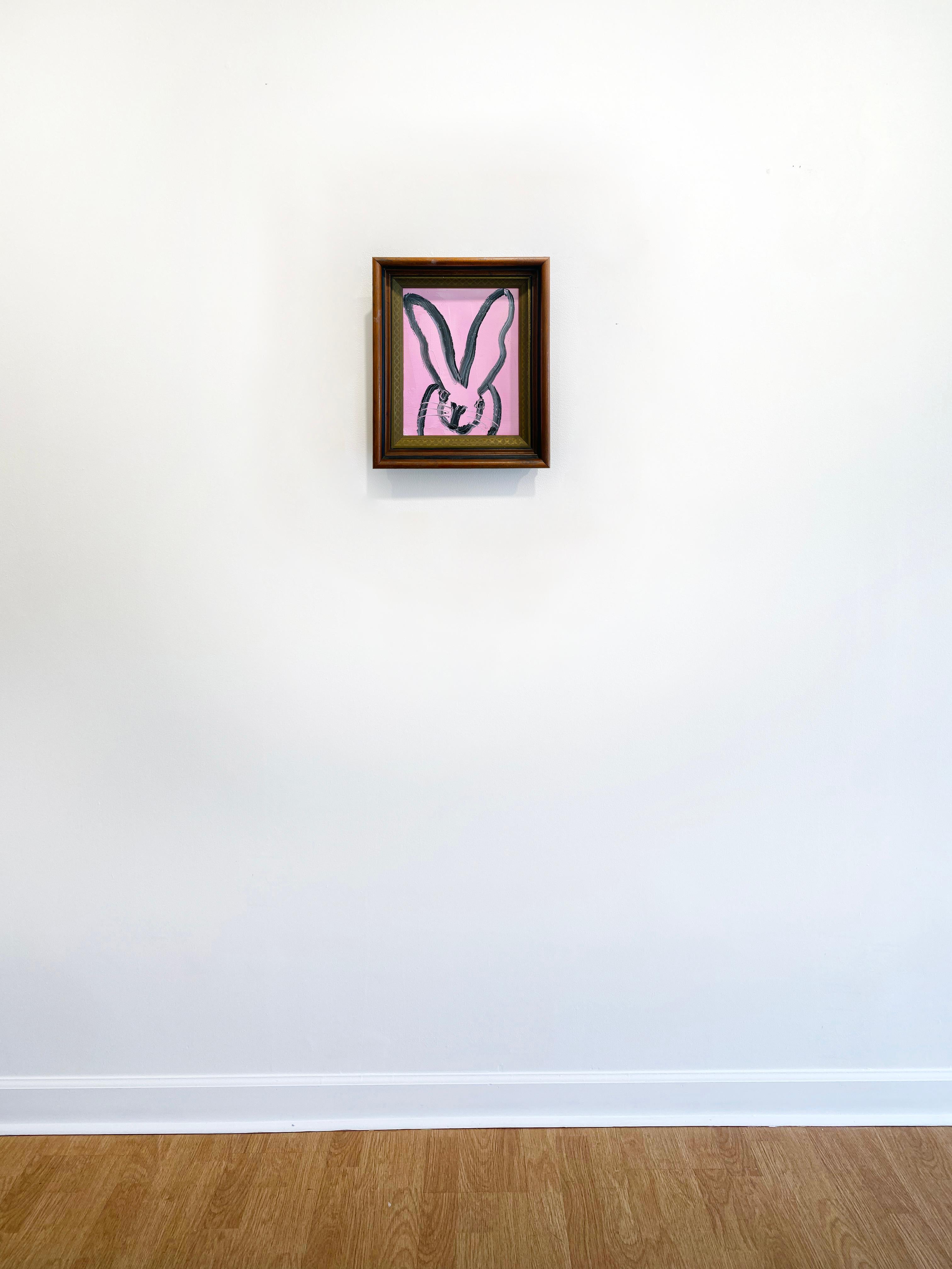 'Poly' by Hunt Slonem, 2021. Oil on wood, 10 x 8 in. Framed size is 13 x 11 in. This painting features Slonem's signature bunny outlined in black on a bright pink background. This charming bunny features an expressive face and long slender ears. 